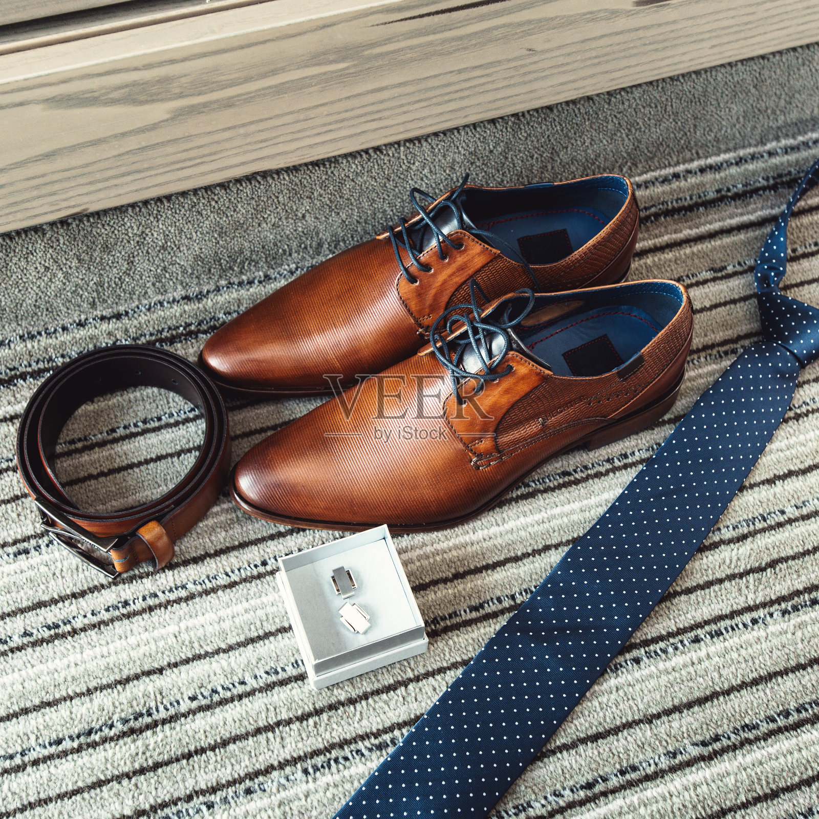新郎的棕色鞋子,蓝色领带,腰带和袖扣照片摄影图片