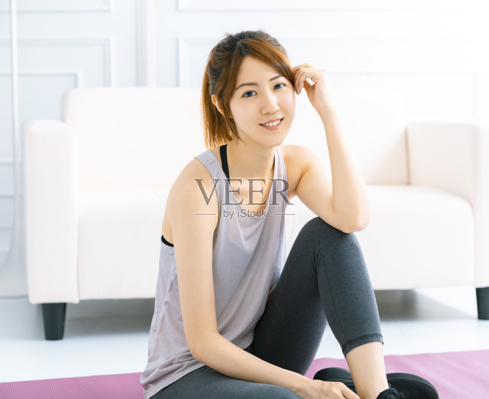 年轻女子在家里的客厅里练瑜伽照片摄影图片