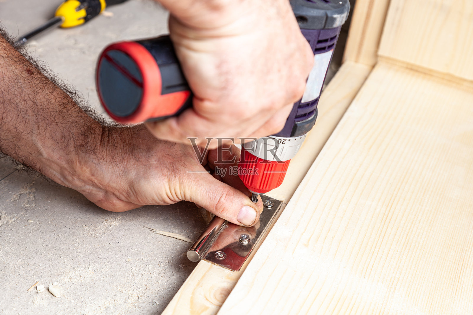 一个木匠在木板上拧铰链的特写照片摄影图片