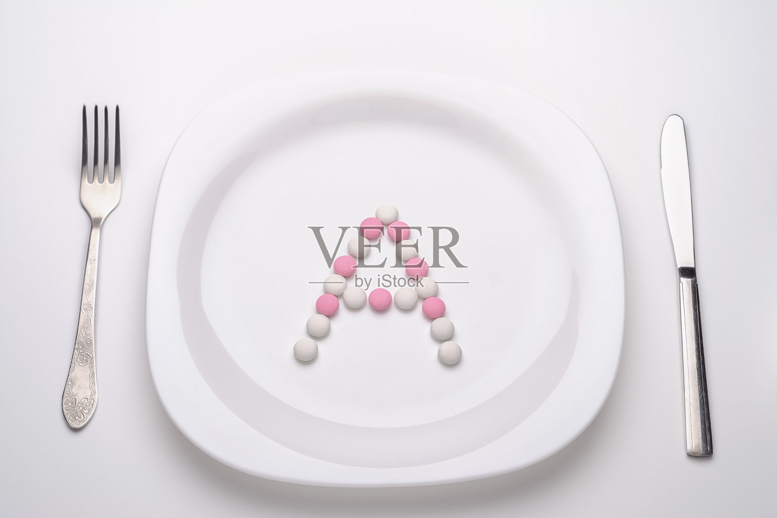 维生素片放在盘子和餐具附近照片摄影图片