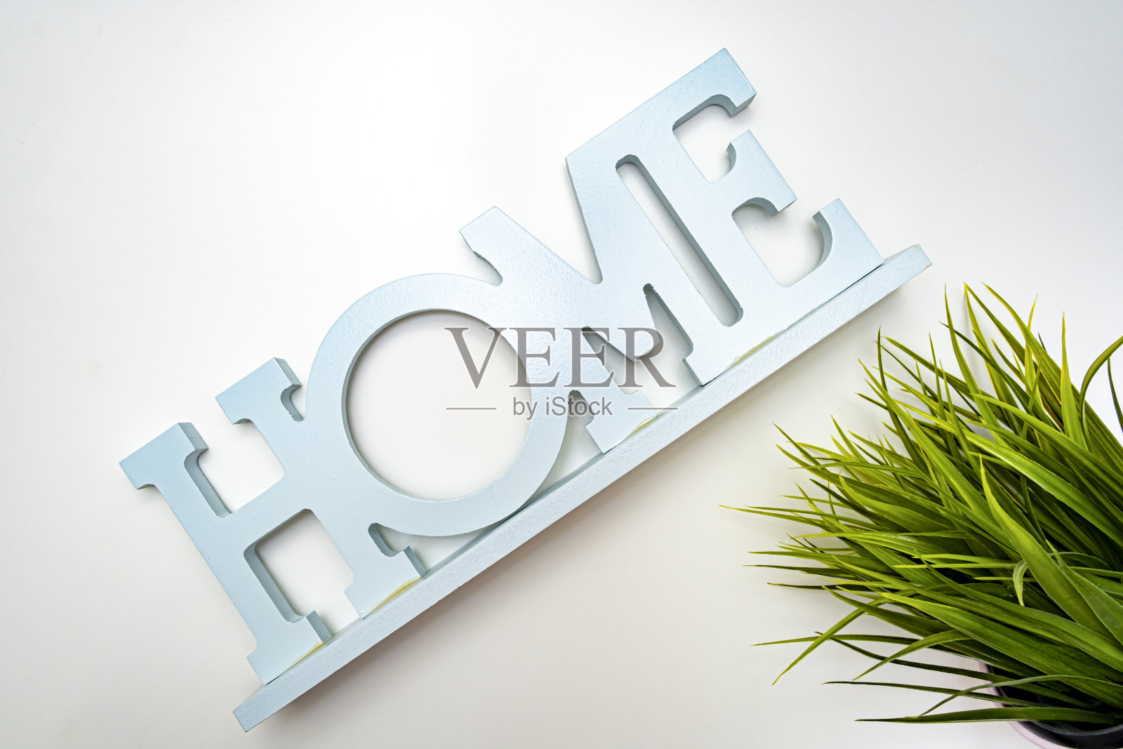 绿色的草地和白色背景下的家的标志,生态友好的家庭概念照片摄影图片