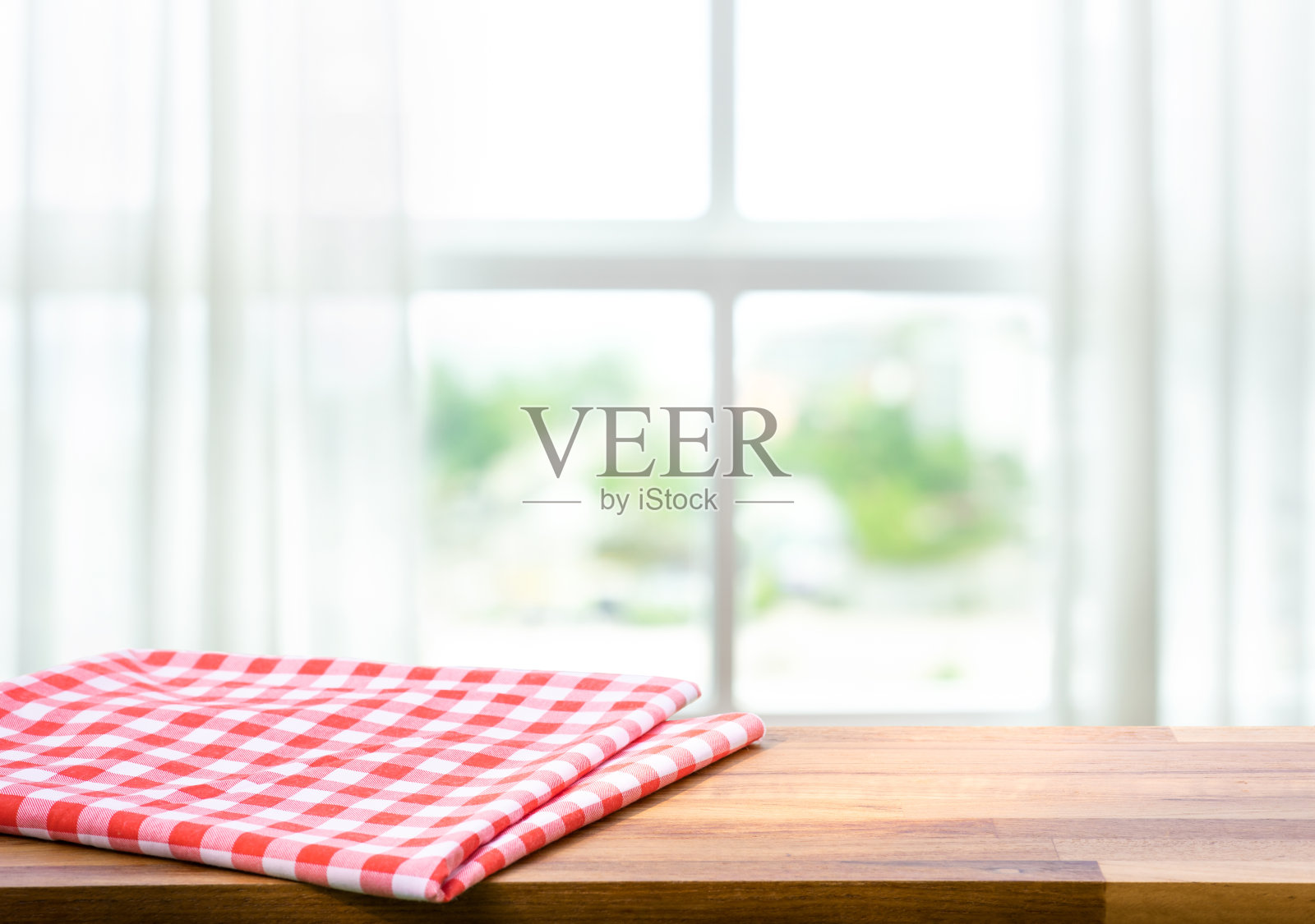 红色的织物,布在木头桌面上模糊的窗户在早晨的背景。为蒙太奇产品展示或设计重点视觉照片摄影图片