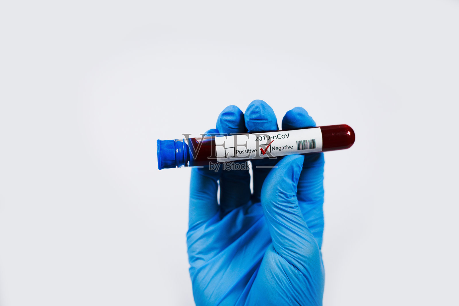 手握含有血液阴性样本的试管,试管中含有用于Covid-19(冠状病毒)分析的血液。化验病人的血液。蓝色的丁腈手套。照片摄影图片