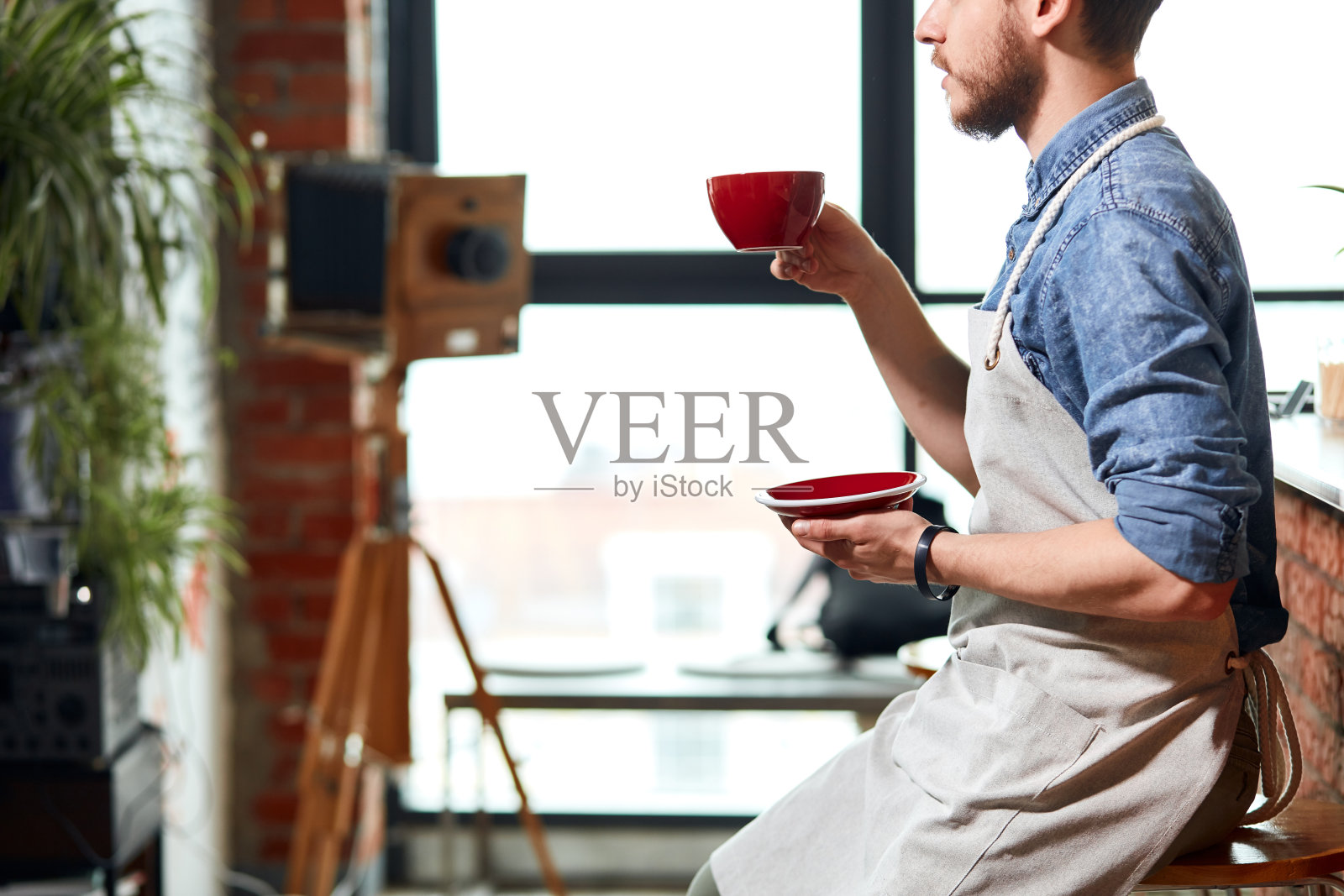 时髦的咖啡师拿着一杯咖啡照片摄影图片