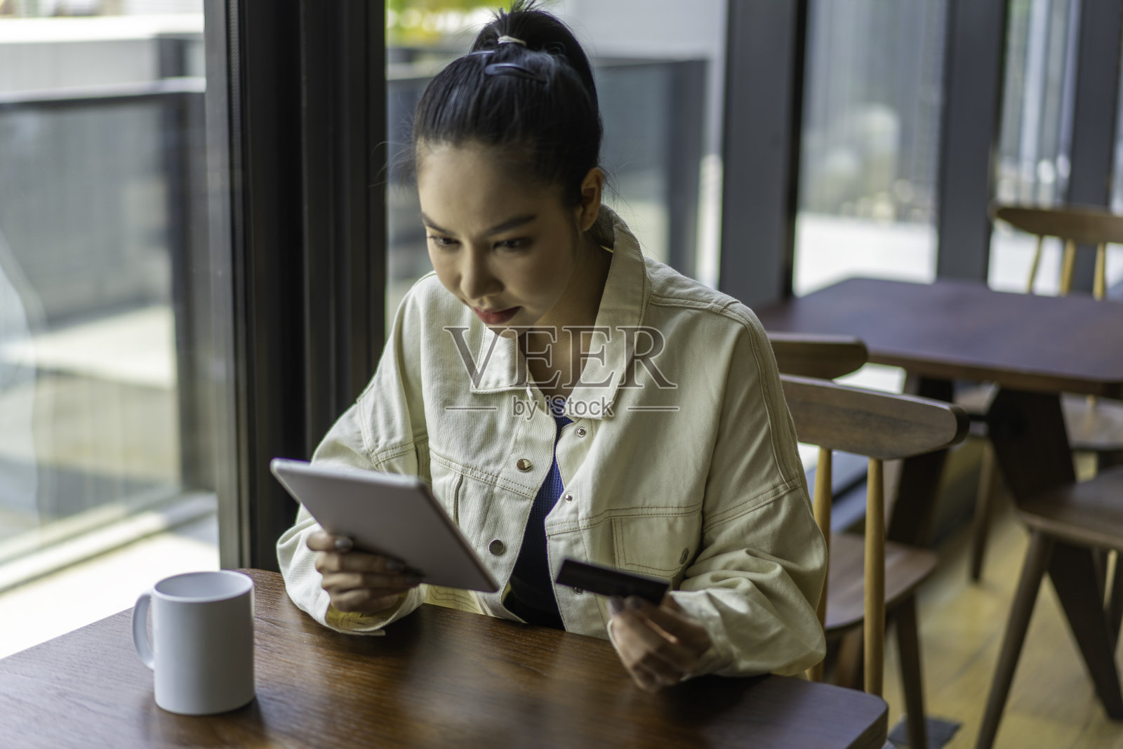 年轻的亚洲千禧一代使用手机和信用卡购物。照片摄影图片