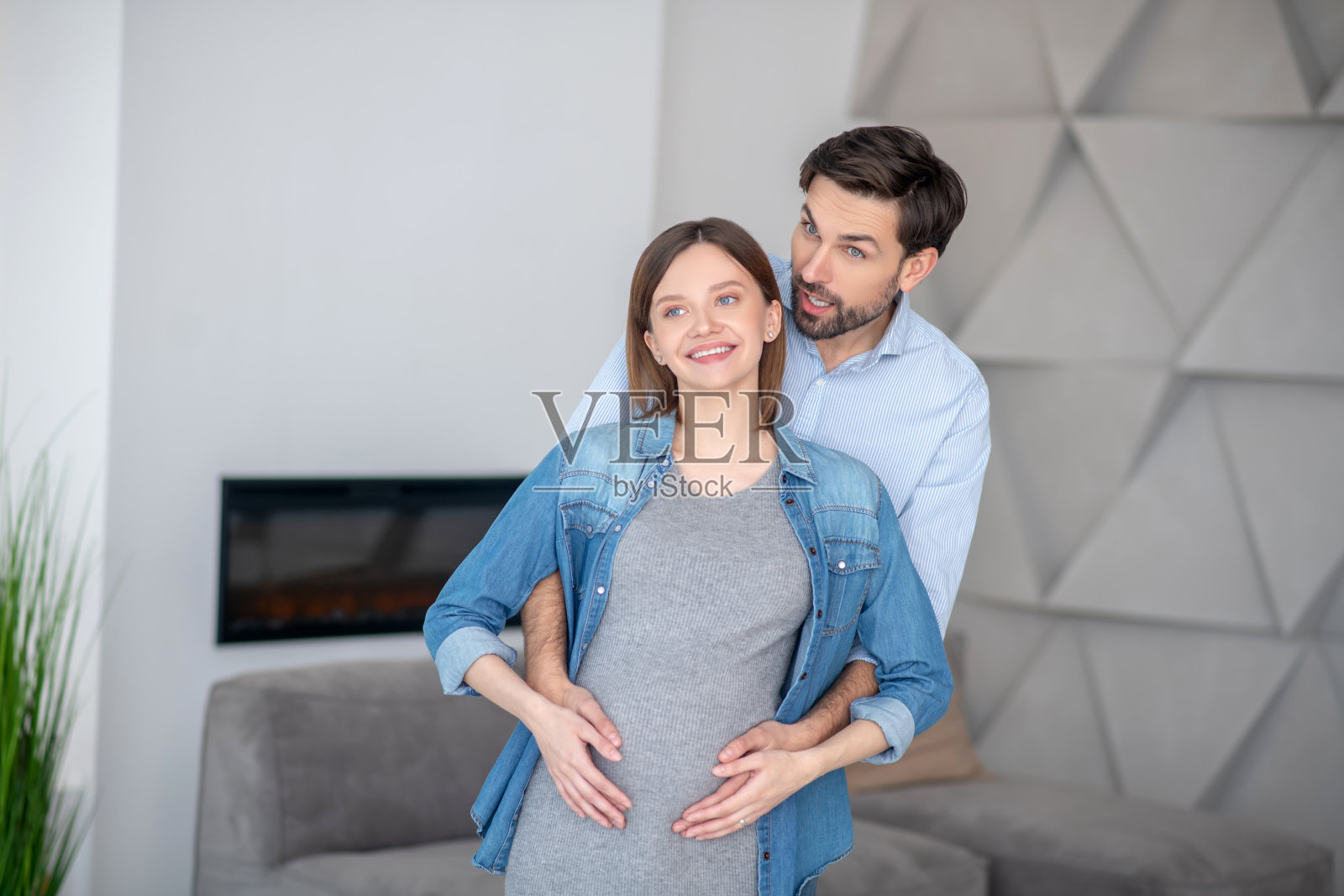 年轻的黑发抚摸着他怀孕的妻子照片摄影图片