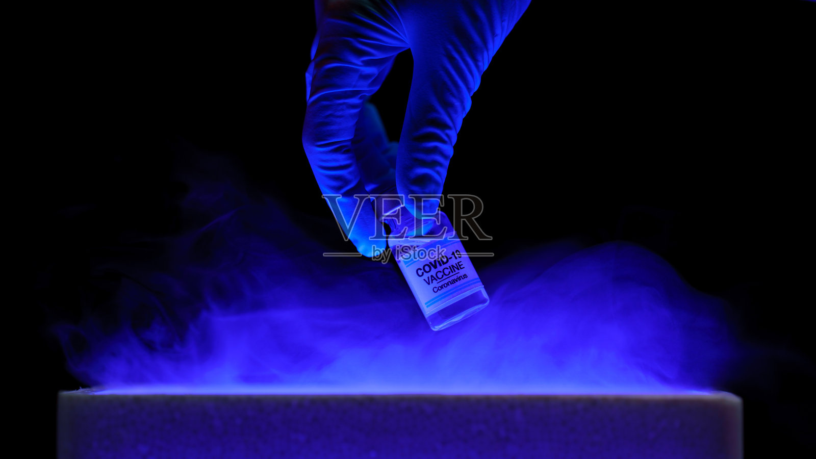 医生手持瓶状Covid-19疫苗从储物箱中取出。药物治疗的概念。照片摄影图片