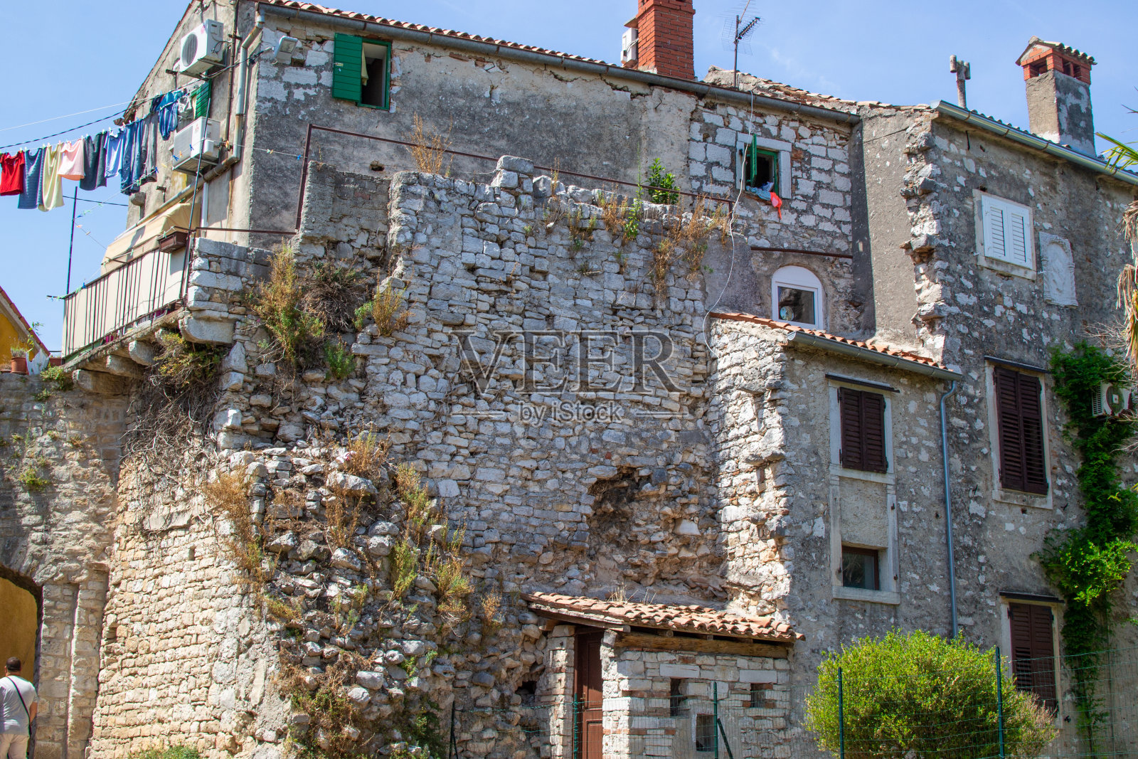 在克罗地亚伊斯特里亚半岛的旧城Porec (Parenzo),一个被毁坏的旧房子的正面照片摄影图片