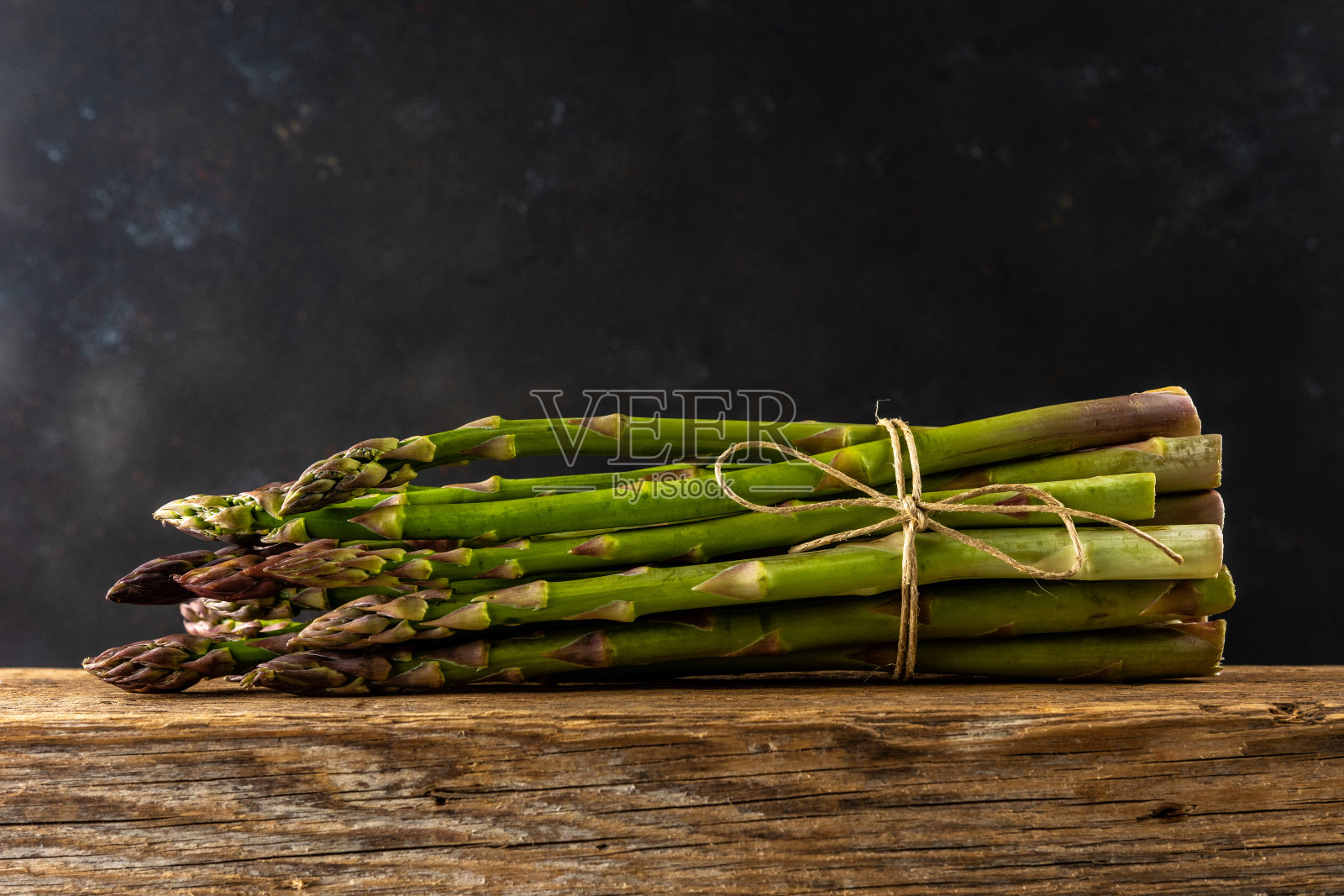 木桌上的新鲜芦笋。食品的背景。照片摄影图片