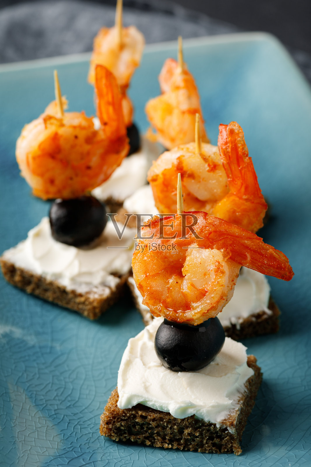 配烤虾、橄榄、奶油芝士和面包的开胃小菜。照片摄影图片