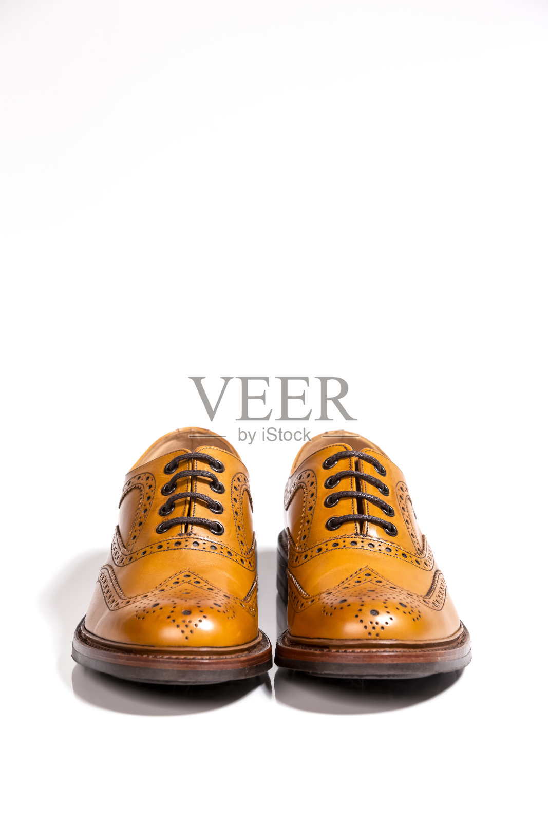 奢侈男士鞋的概念。全布罗格棕色皮革牛津鞋隔离在白色背景。垂直的图像照片摄影图片