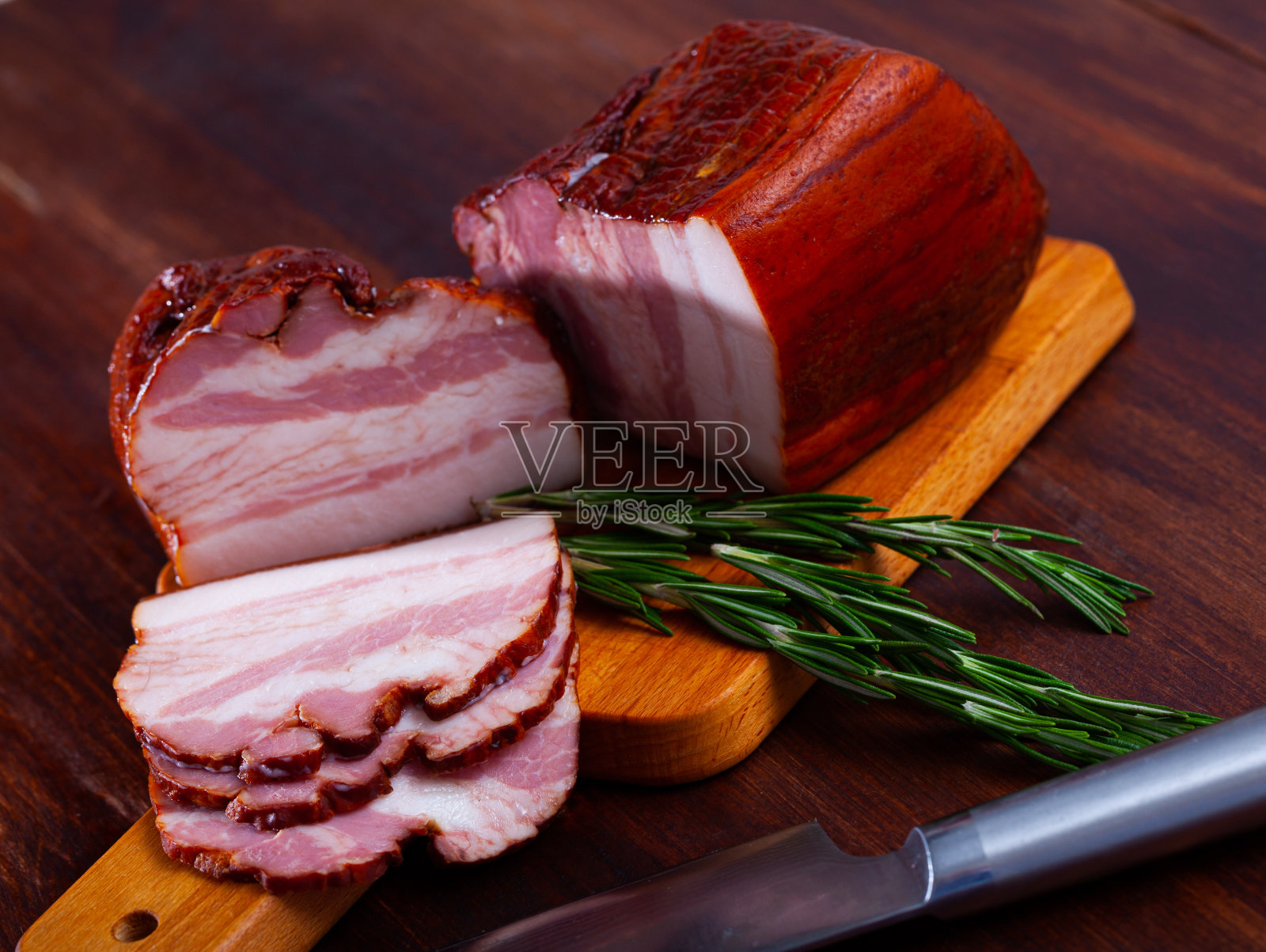 俄罗斯小吃烟熏牛胸肉切片,放在木板上照片摄影图片