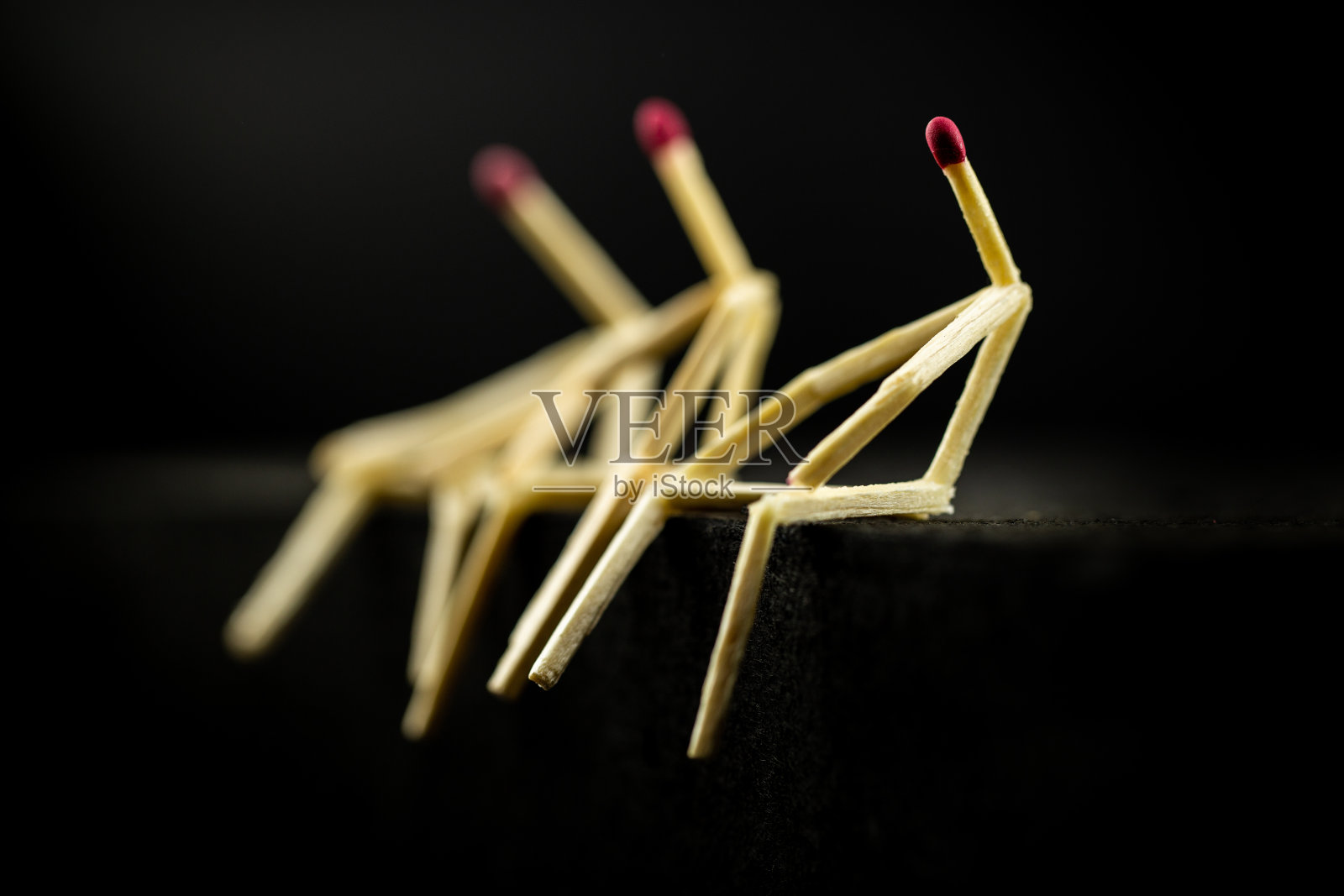 孤独或抑郁的概念:三个男人拿着火柴坐在黑暗中,其中一个悲伤地消失了照片摄影图片