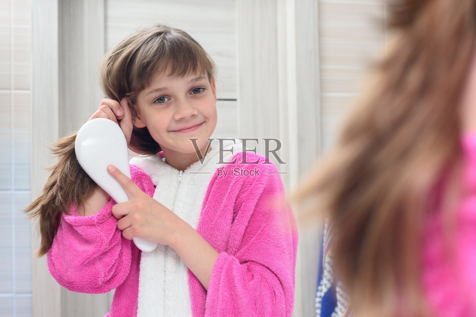 快乐女孩在浴室梳头照片摄影图片