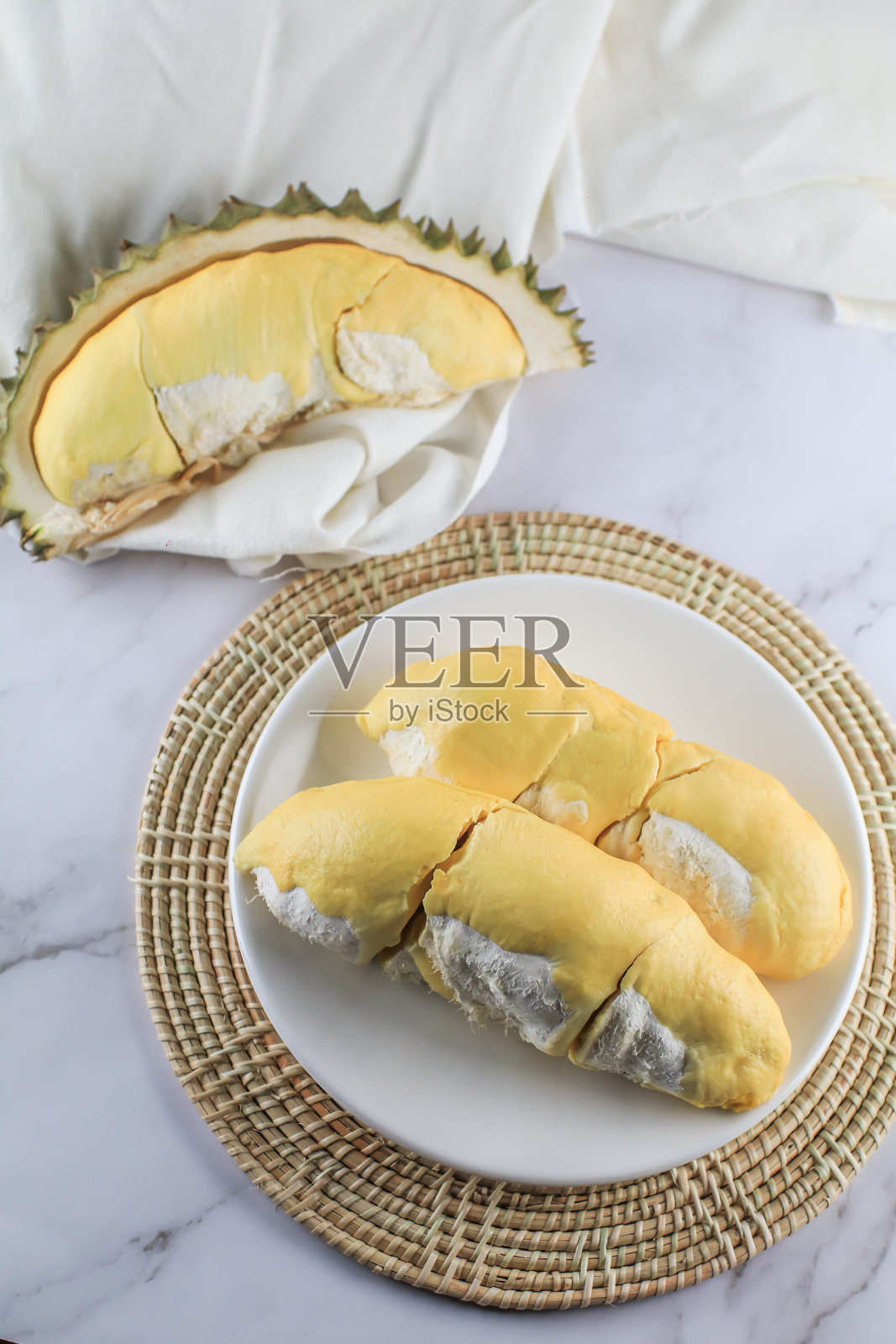 近距离观察泰国水果之王榴莲。夏季泰国传统热带水果如此美味,果皮带刺,香甜可口。成熟的榴莲已剥皮呈金黄色。照片摄影图片