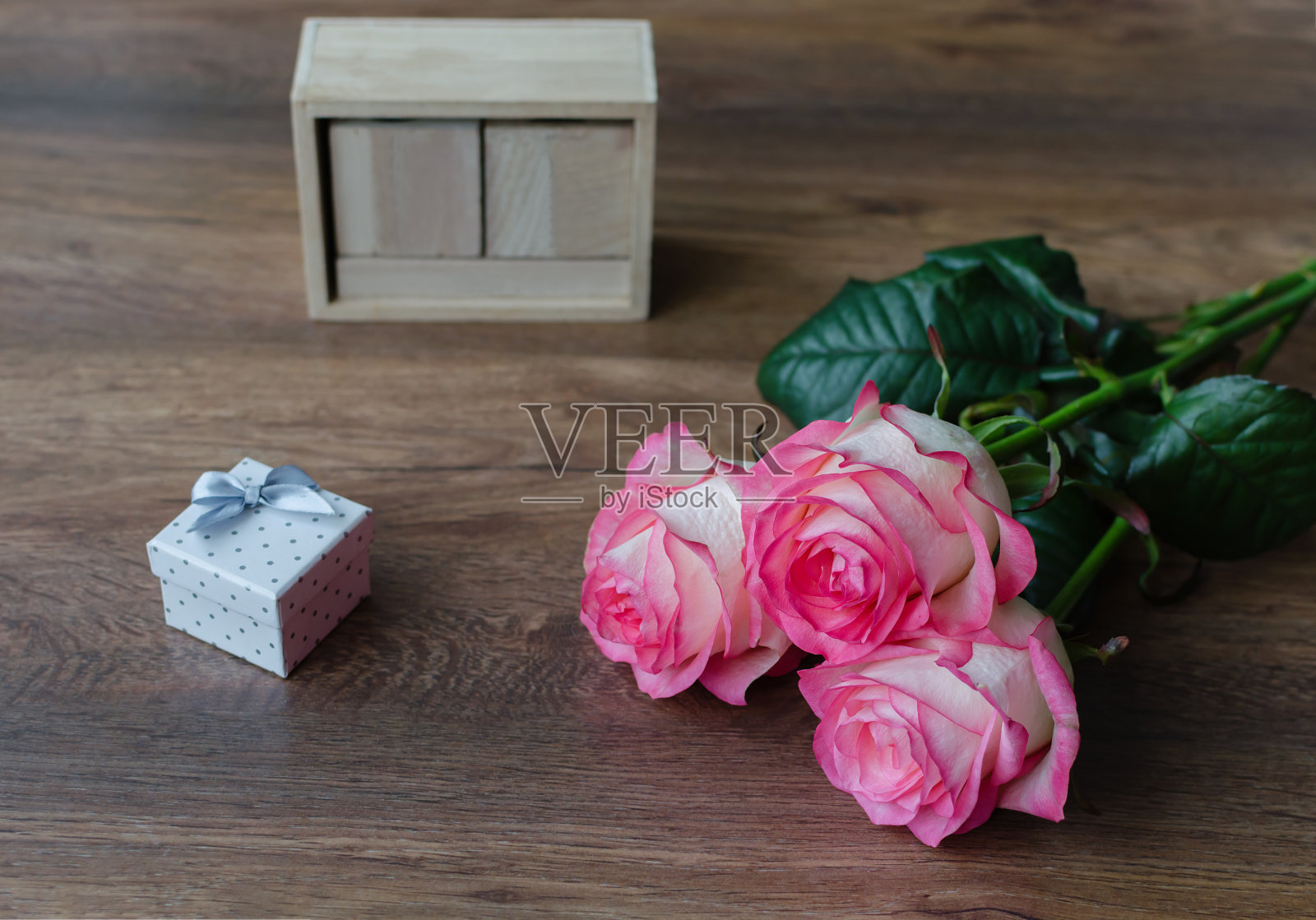 木质背景上点缀着粉红色的玫瑰鲜花照片摄影图片