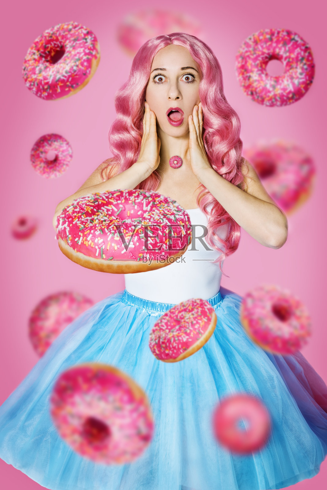 漂亮的女孩,粉红色的背景上有一头粉红色的长卷发照片摄影图片