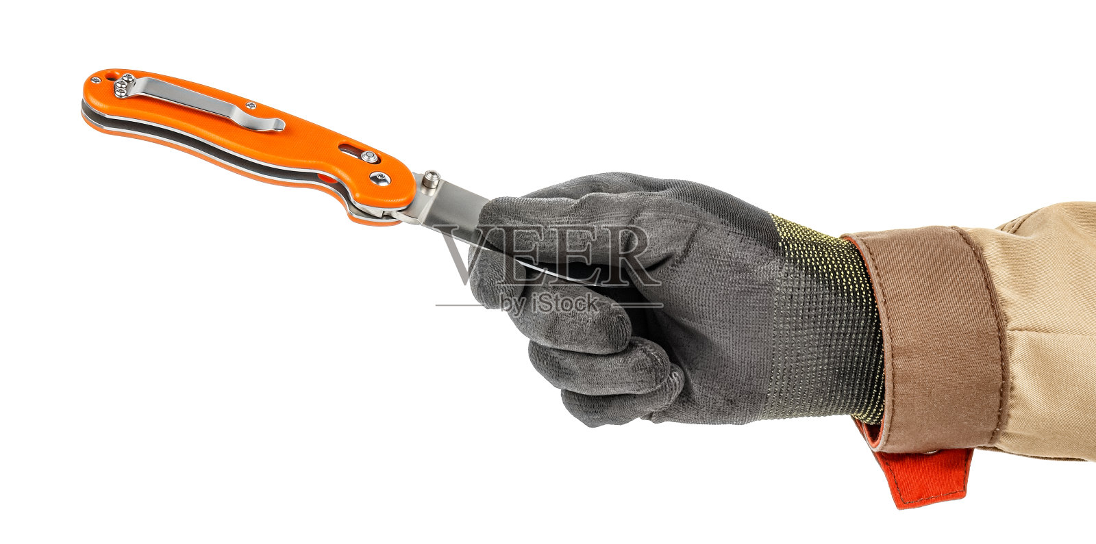 工人手戴黑色防护手套和棕色制服,用手指握住开着的带有亮橙色手柄的小刀刀片,孤立在白色背景上照片摄影图片