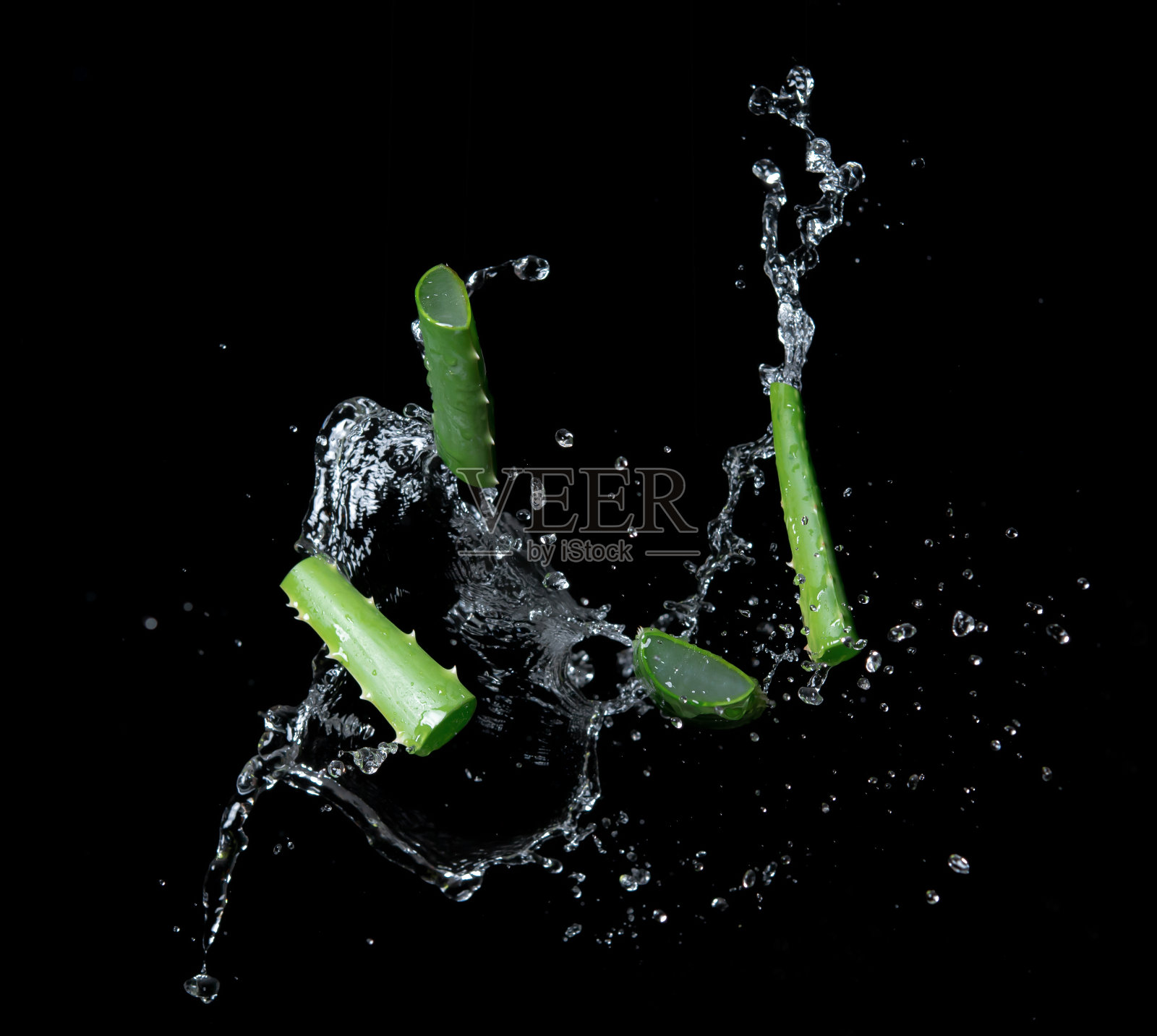 芦荟片与水溅在黑色背景照片摄影图片