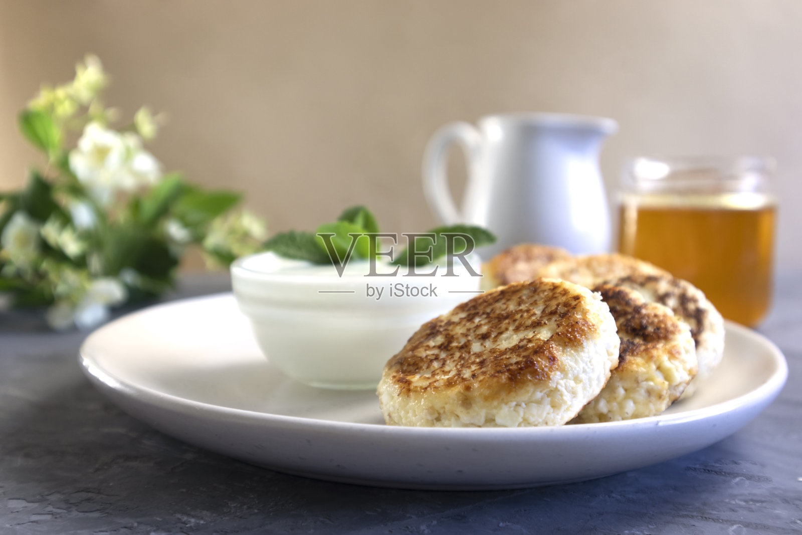 奶酪煎饼或凝乳煎饼配酸奶油和蜂蜜,俄罗斯雪梨照片摄影图片