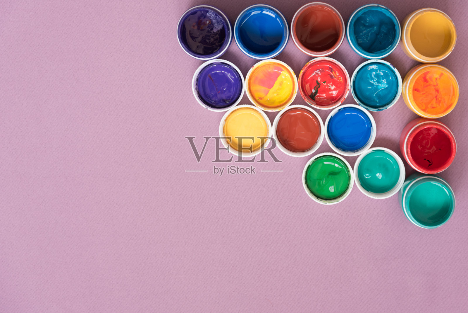 美丽的明信片和水粉罐子。粉色背景,文字空间。五颜六色的颜料,一罐带盖的水粉画。背景。照片摄影图片