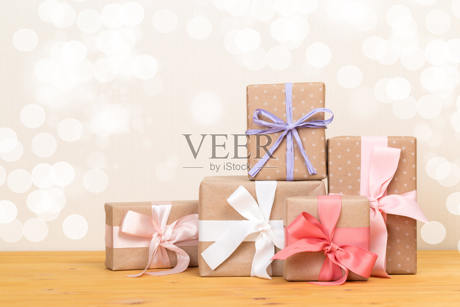 木桌上放着礼品盒。用粉红色丝带包装的礼物。节日贺卡。照片摄影图片