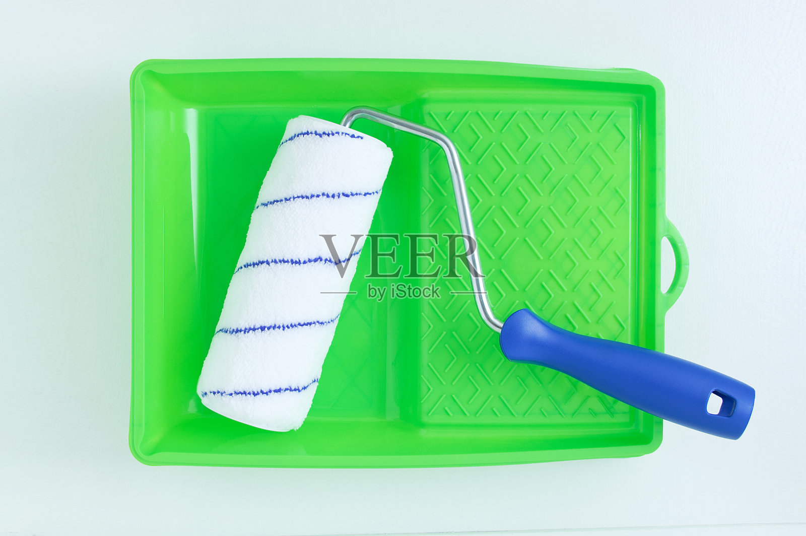 涂漆和施工用的绿色试管,白色背景上有一支笔。照片摄影图片