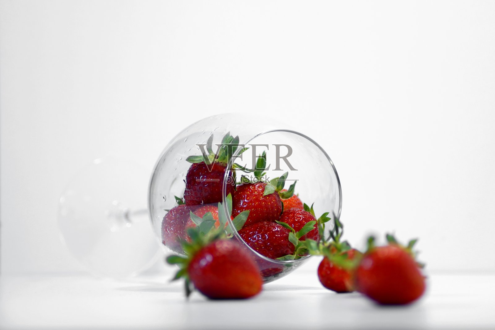 大草莓在一个倒置的玻璃在一个明亮的背景与明亮的照明特写照片摄影图片