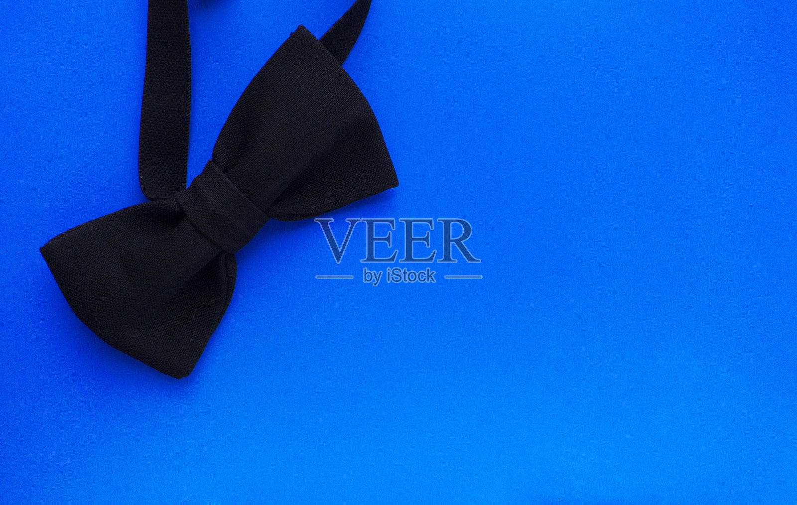蓝色背景上的黑人领结。男人的配件。从以上观点。照片摄影图片