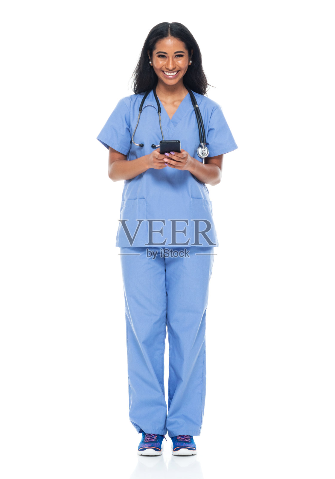 拉丁美洲和西班牙裔女性站在白人背景前使用手机照片摄影图片