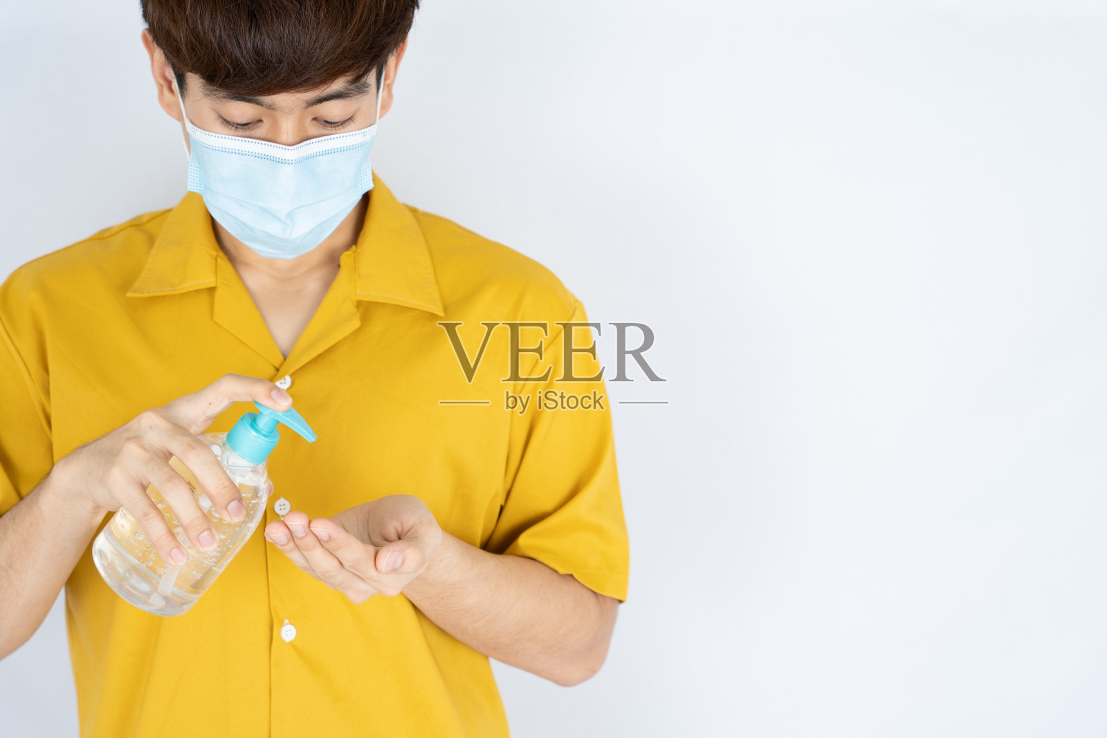 亚洲英俊快乐的潮人戴着医用防护口罩保护冠状病毒,过滤灰尘PM 2.5和寒冷,使用洗手液洗手液在白色背景照片摄影图片