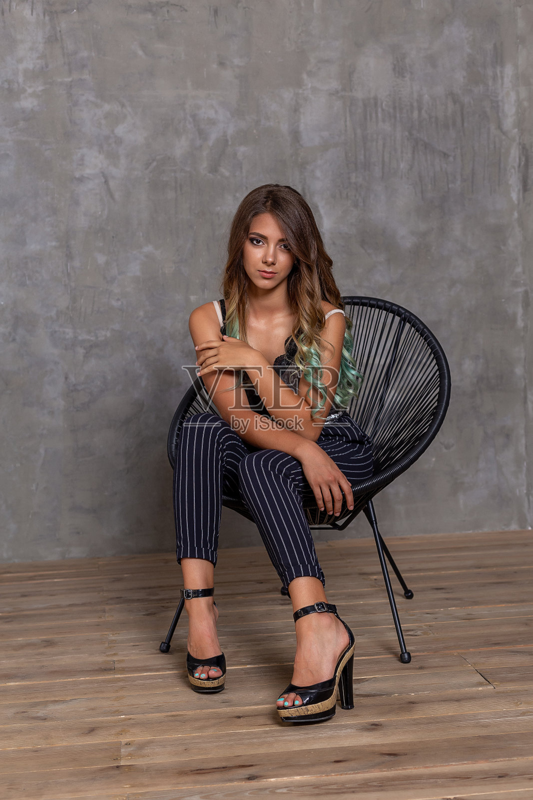 特写肖像的女人。年轻满足的时尚女孩在椅子上摆姿势。时尚。照片摄影图片