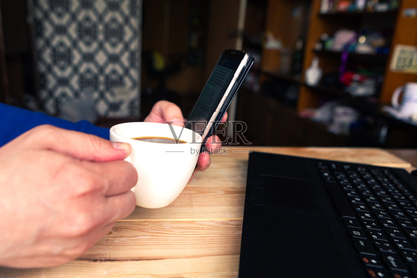 这名男子在家里工作,使用智能手机和笔记本电脑。自由的概念照片摄影图片