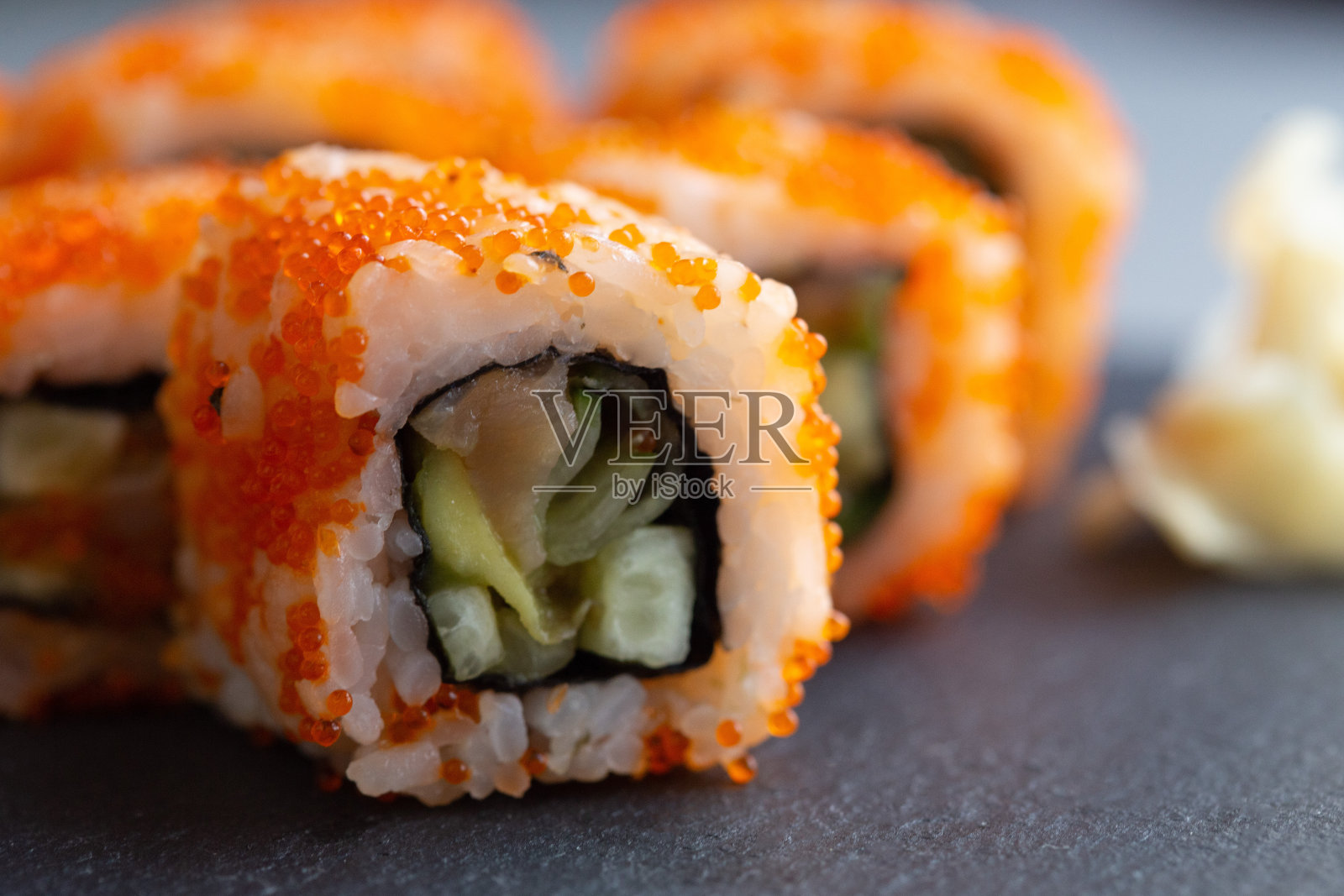 寿司卷特写。日本的食物。加州寿司卷,三文鱼,蔬菜和鱼子酱特写。日本餐厅的菜单照片摄影图片