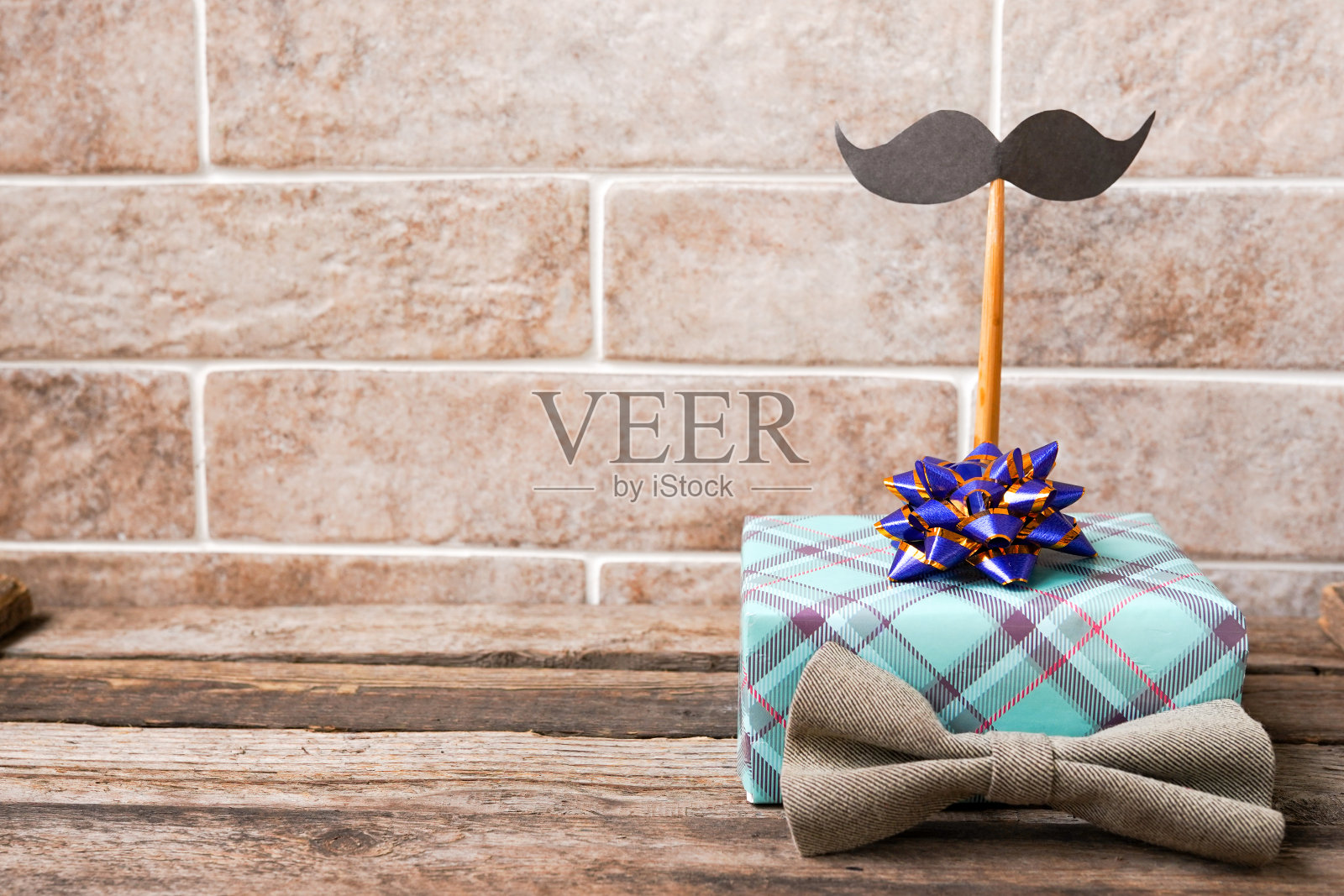 绿色礼盒,蝴蝶结和小胡子放在有复印空间的木桌上,父亲节快乐照片摄影图片