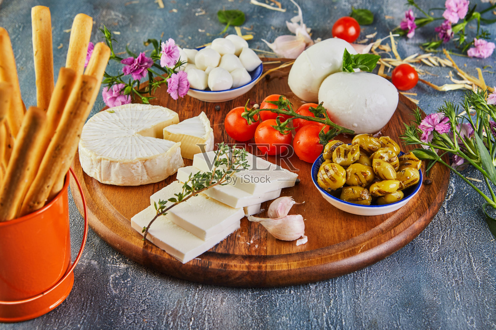 各种形状和口味的奶酪,搭配樱桃番茄和烟熏橄榄照片摄影图片