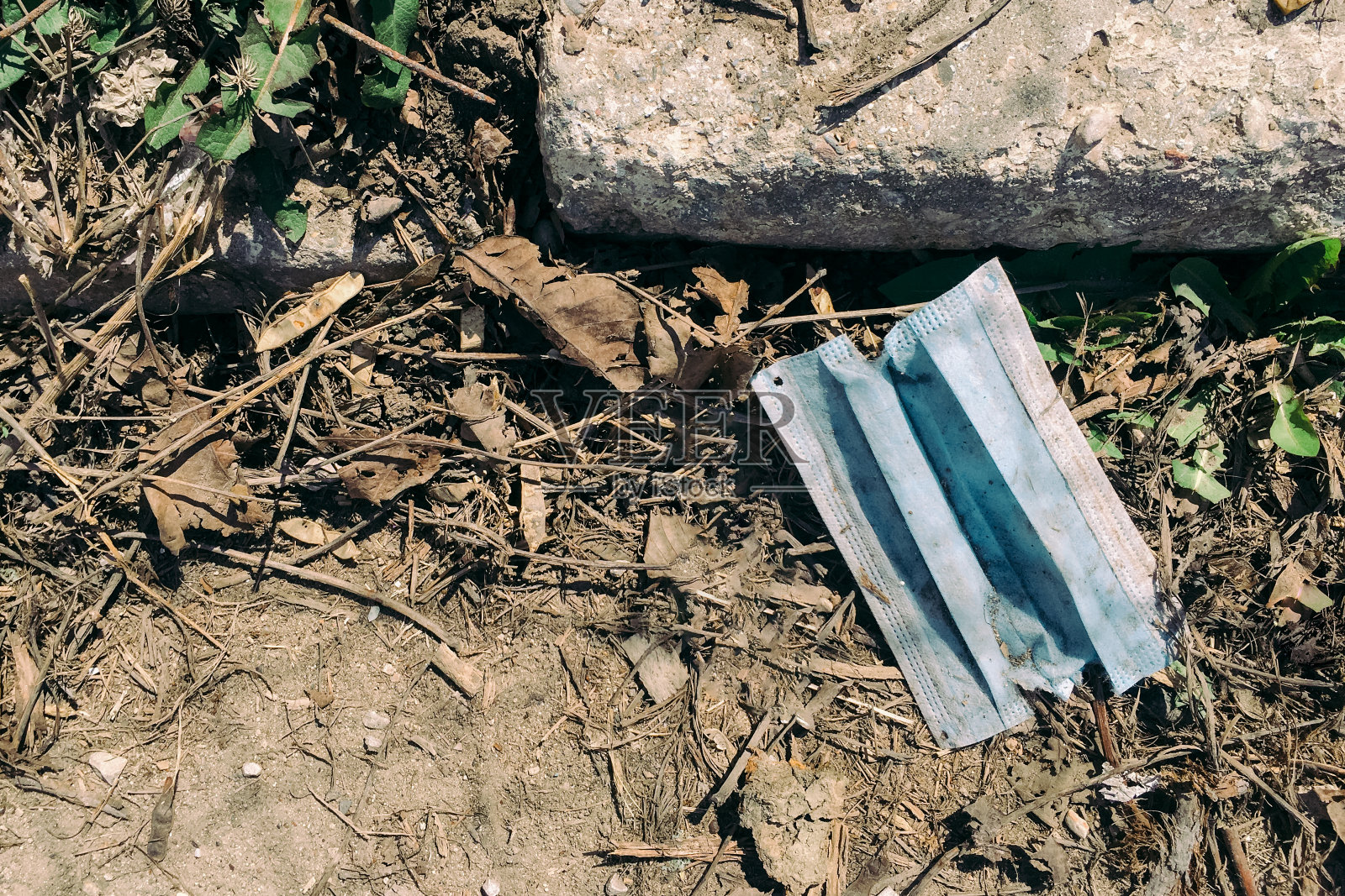 2019冠状病毒病大流行期间被丢弃在地上的医用口罩照片摄影图片