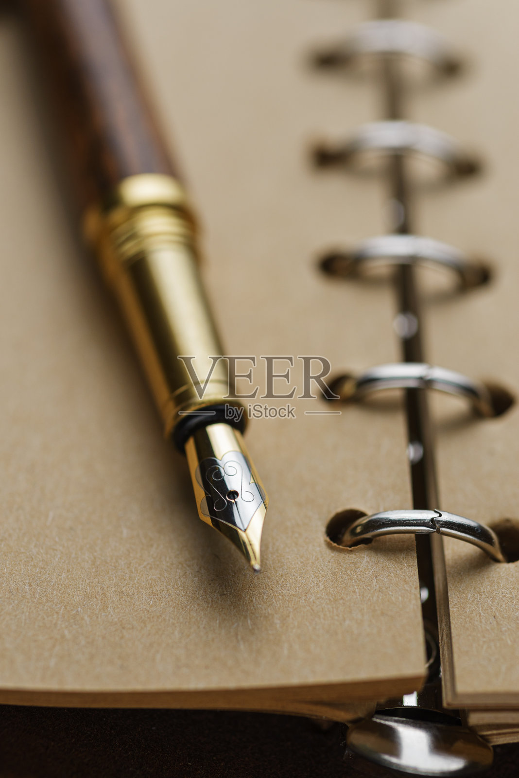 棕色钢笔在一本黄页笔记本上。照片摄影图片