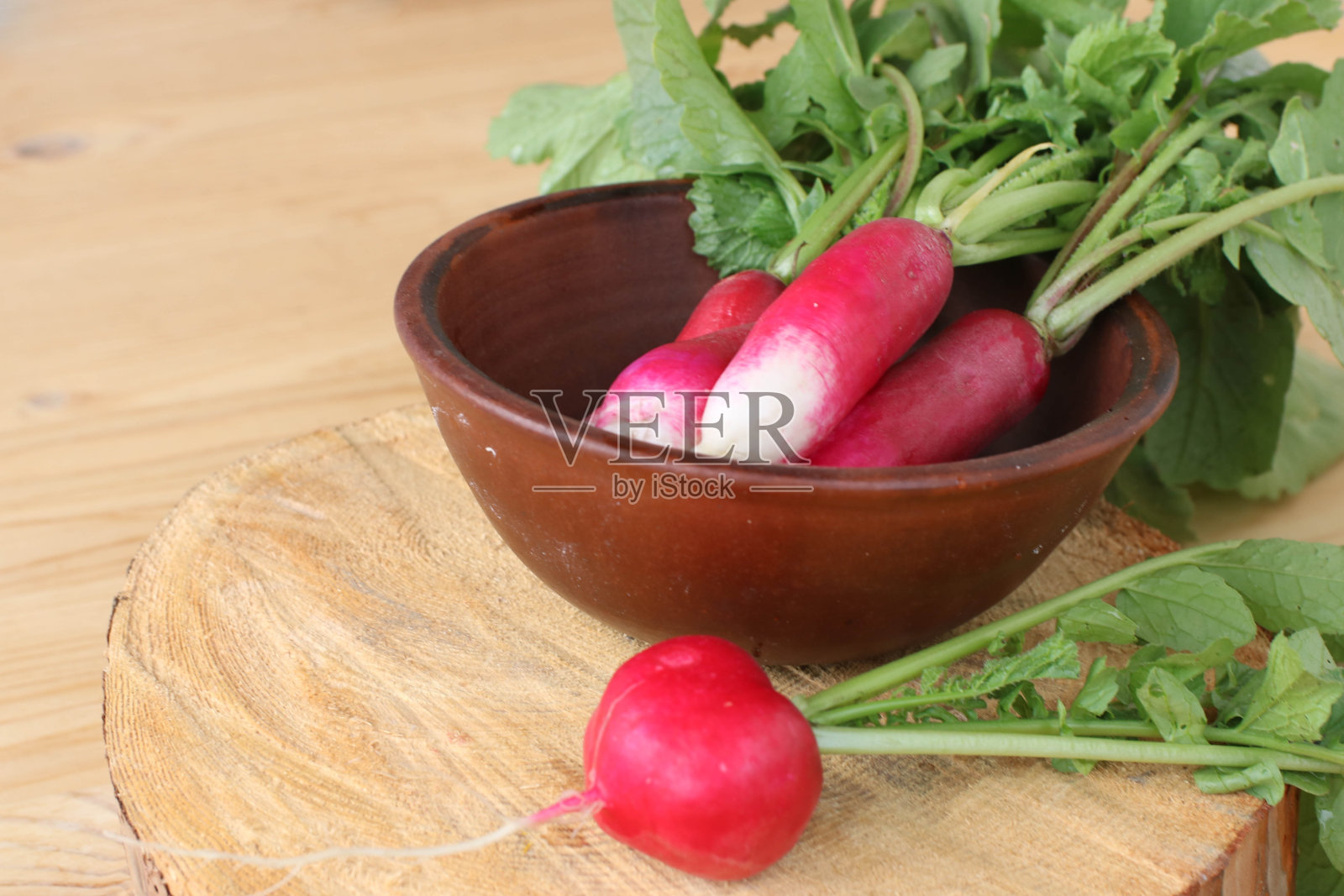 一束花园有机萝卜在陶瓷碗在木背景照片摄影图片