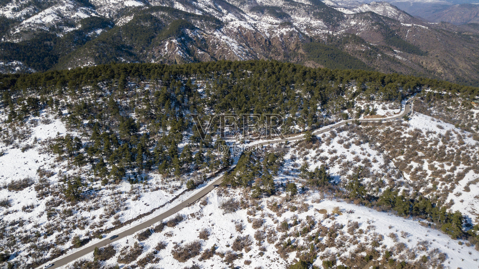 无人机拍摄的美丽雪山冬季弯弯曲曲的道路照片摄影图片