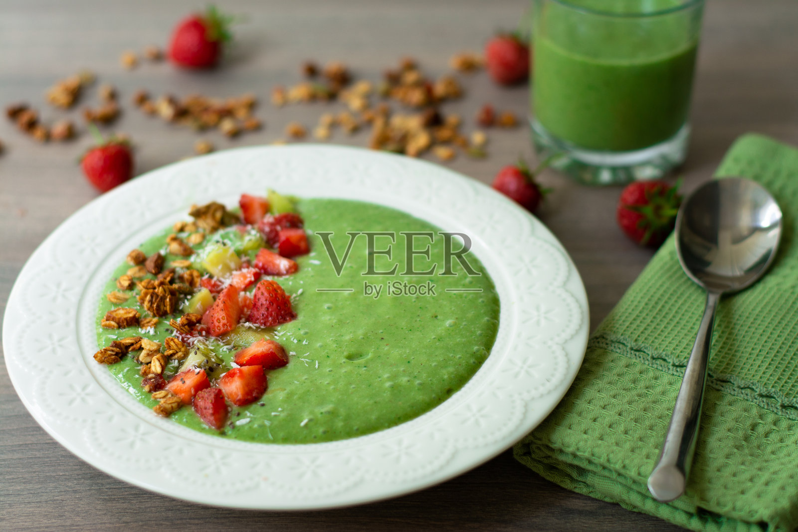 香蕉,草莓,菠菜,甘蓝,猕猴桃,椰奶配自制燕麦,坚果和种子格兰诺拉麦片,椰子片,奇异子,猕猴桃和草莓照片摄影图片