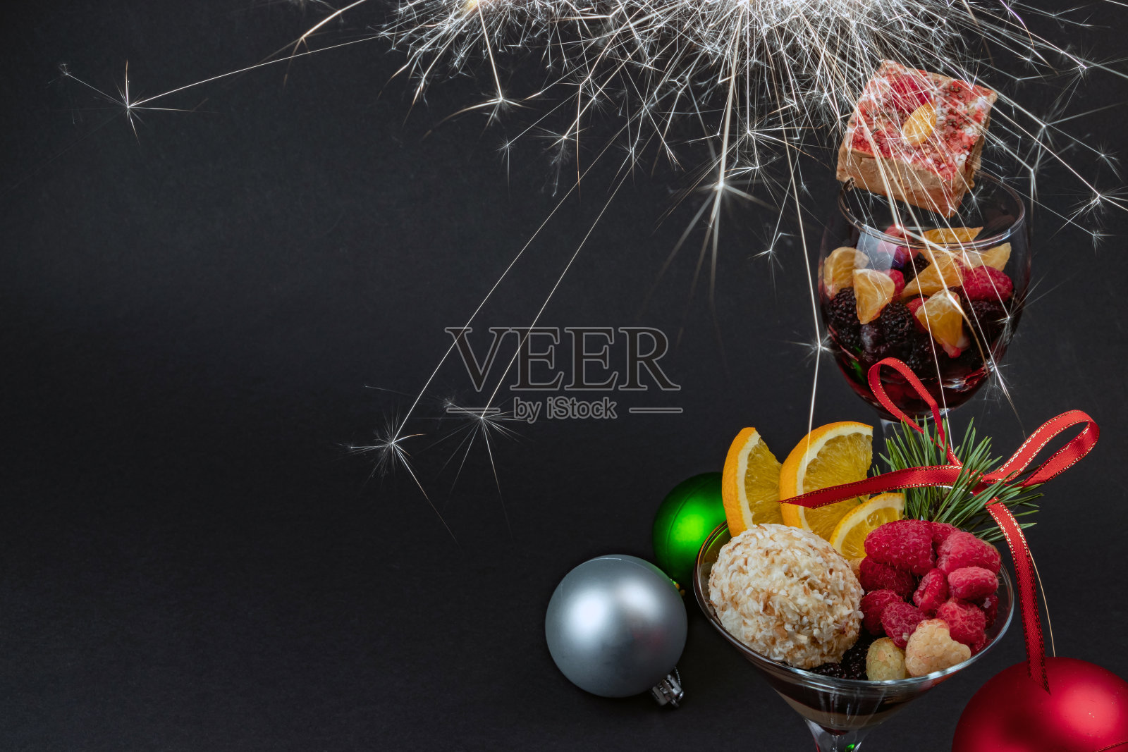 玻璃杯里装着节日糖果和水果,还有圣诞玩具照片摄影图片