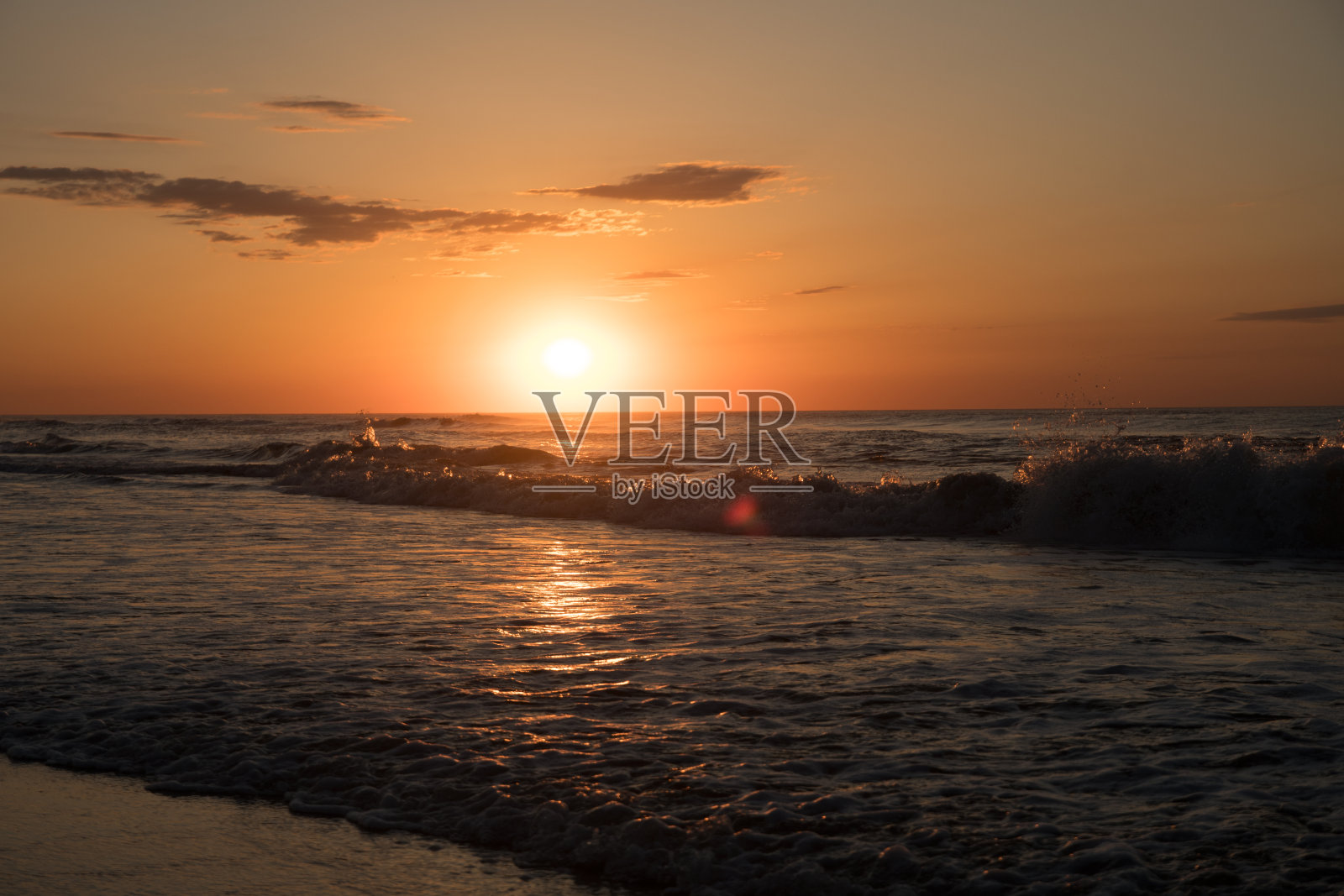 日出和海浪拍打着海滩。照片摄影图片