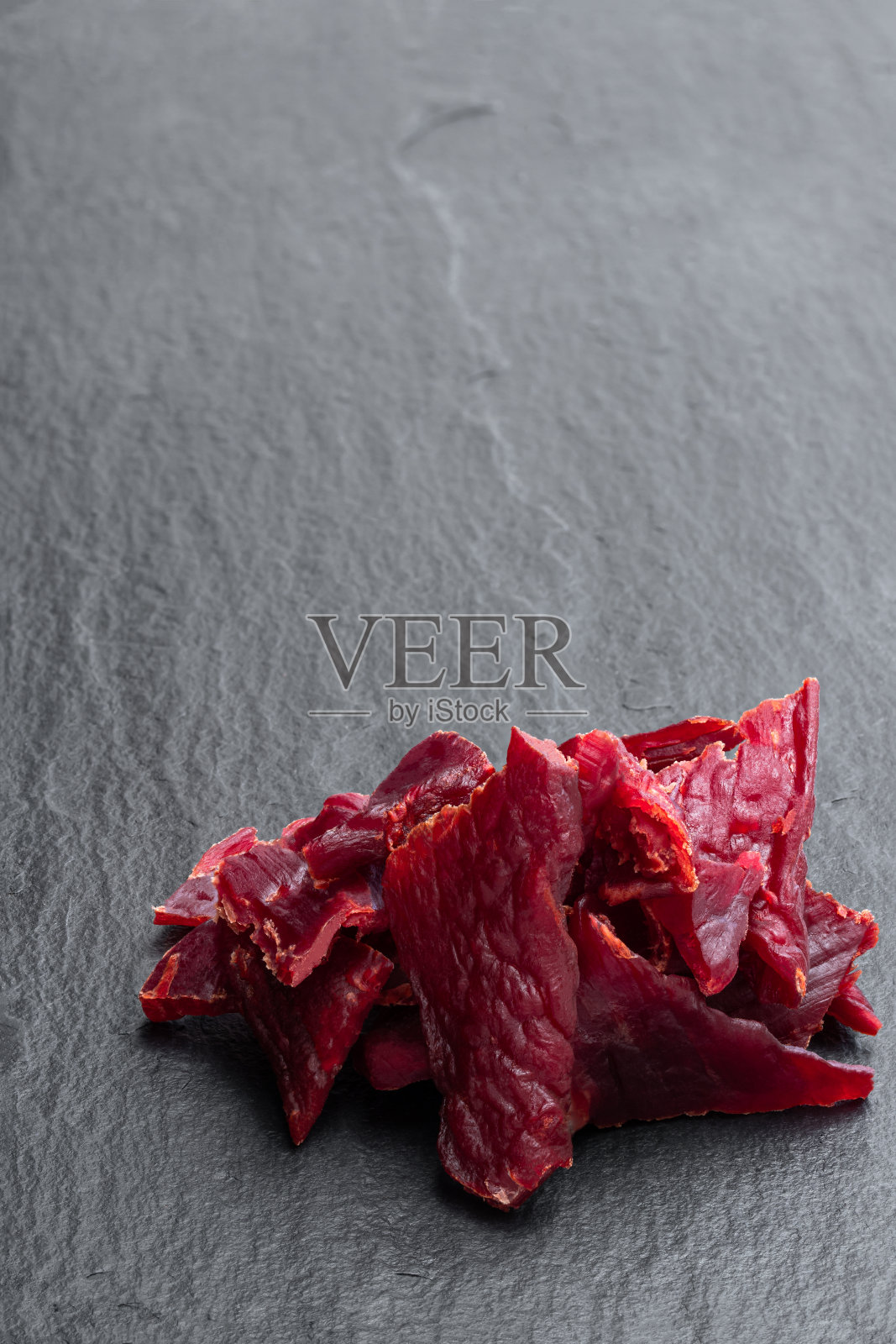 牛肉干块在黑色的石头背景照片摄影图片