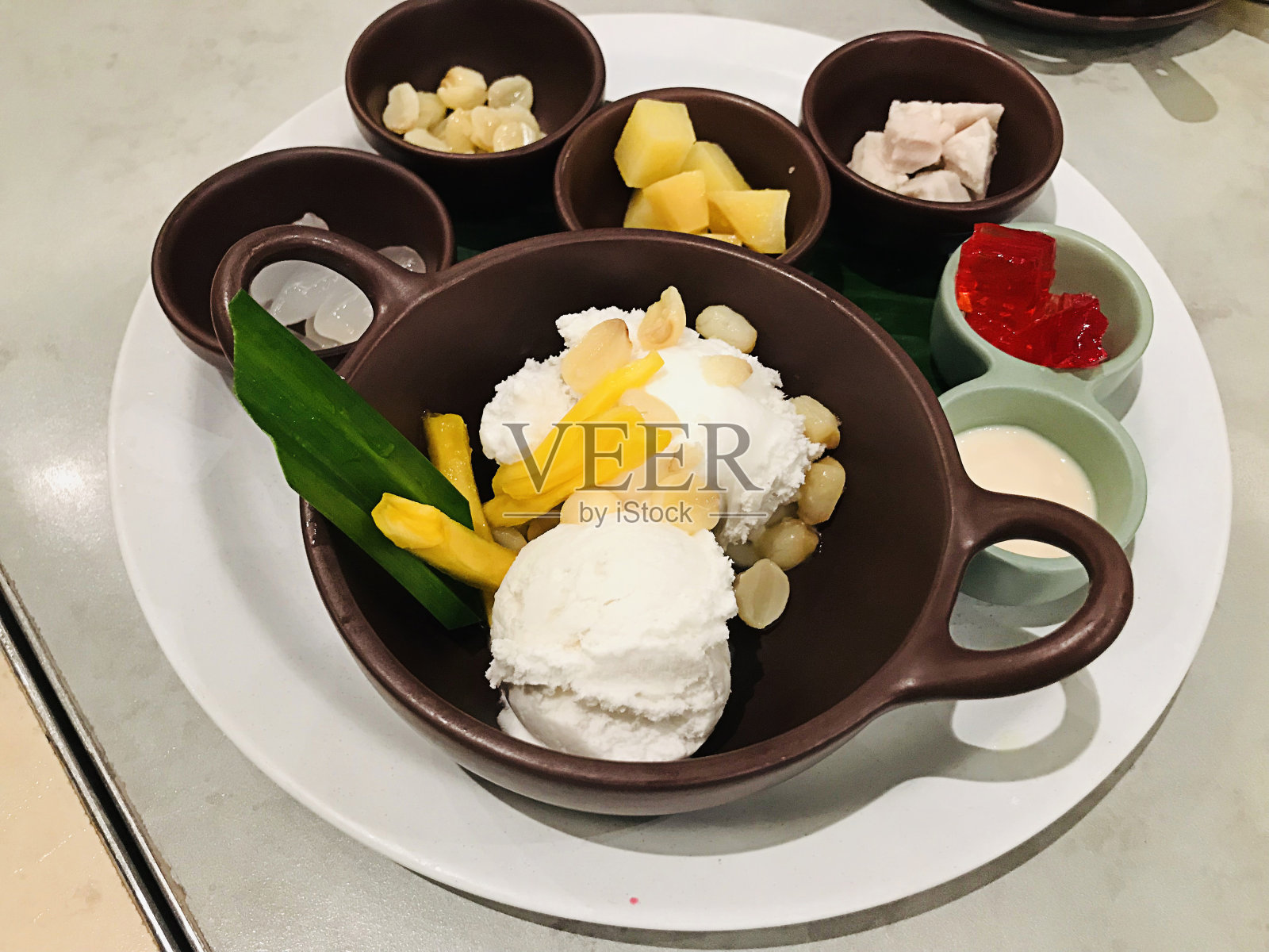 泰国甜点……椰奶冰淇淋配各种配菜。照片摄影图片