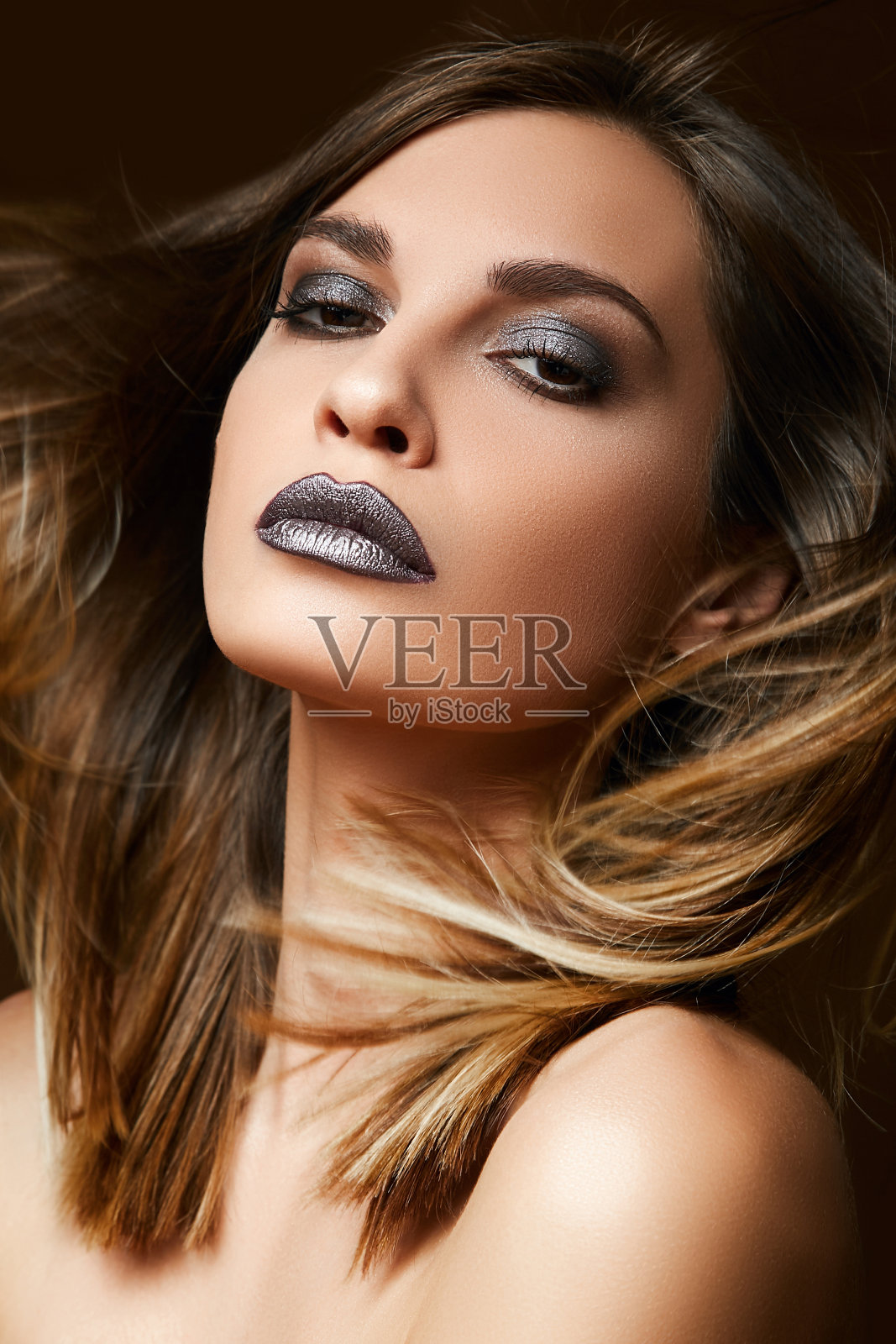 一个美丽的黑发女人的特写肖像。女孩脸上奢华的晚妆。照片摄影图片