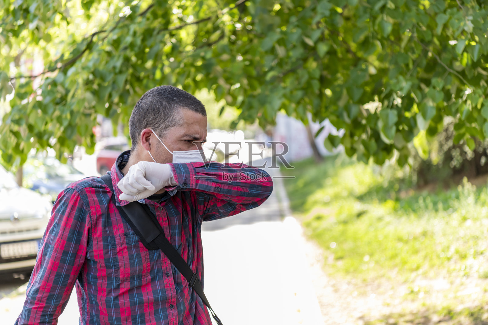 街上一名男子因潜在的病毒症状而咳嗽。照片摄影图片