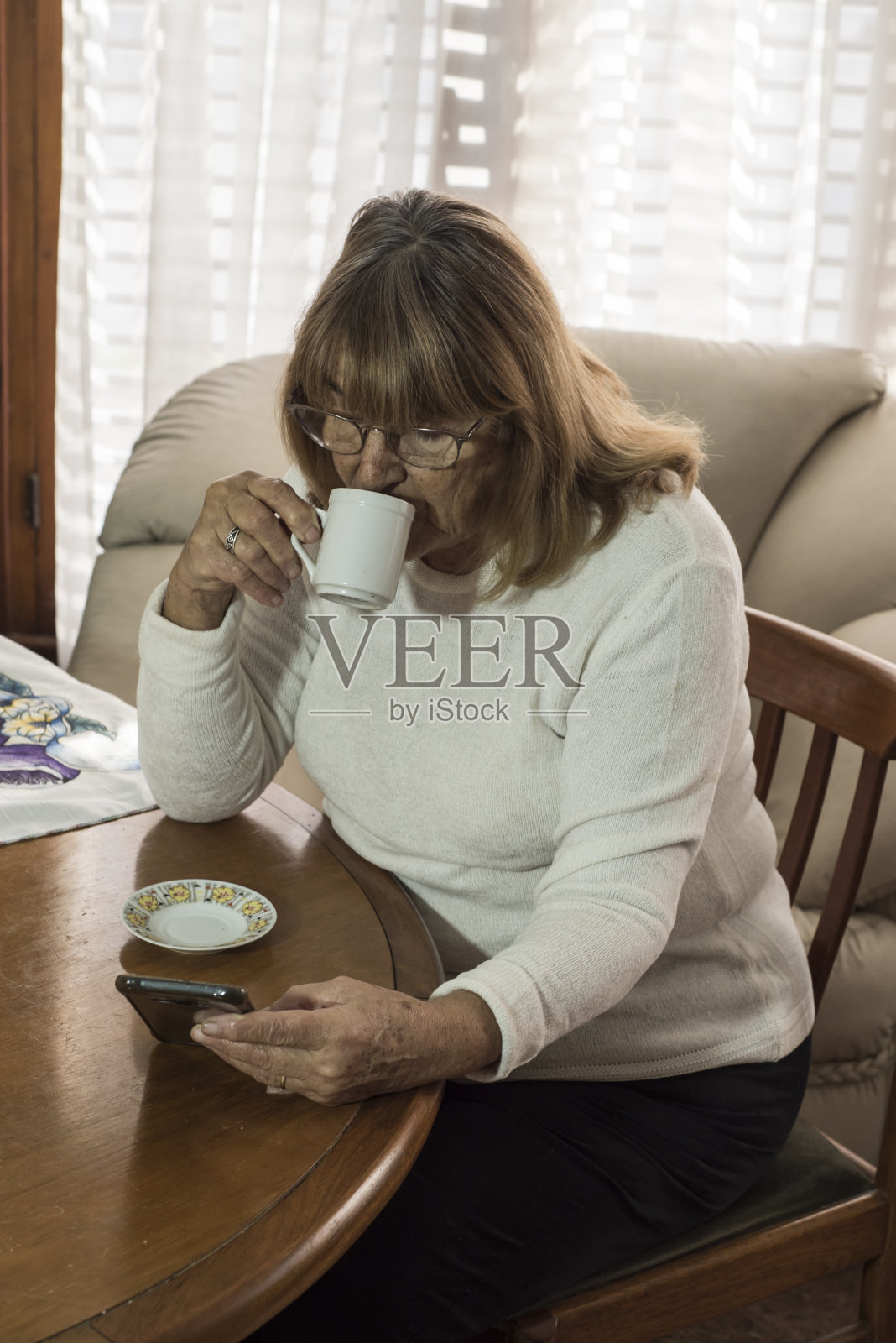 在社交距离中使用现代技术的老年女性照片摄影图片