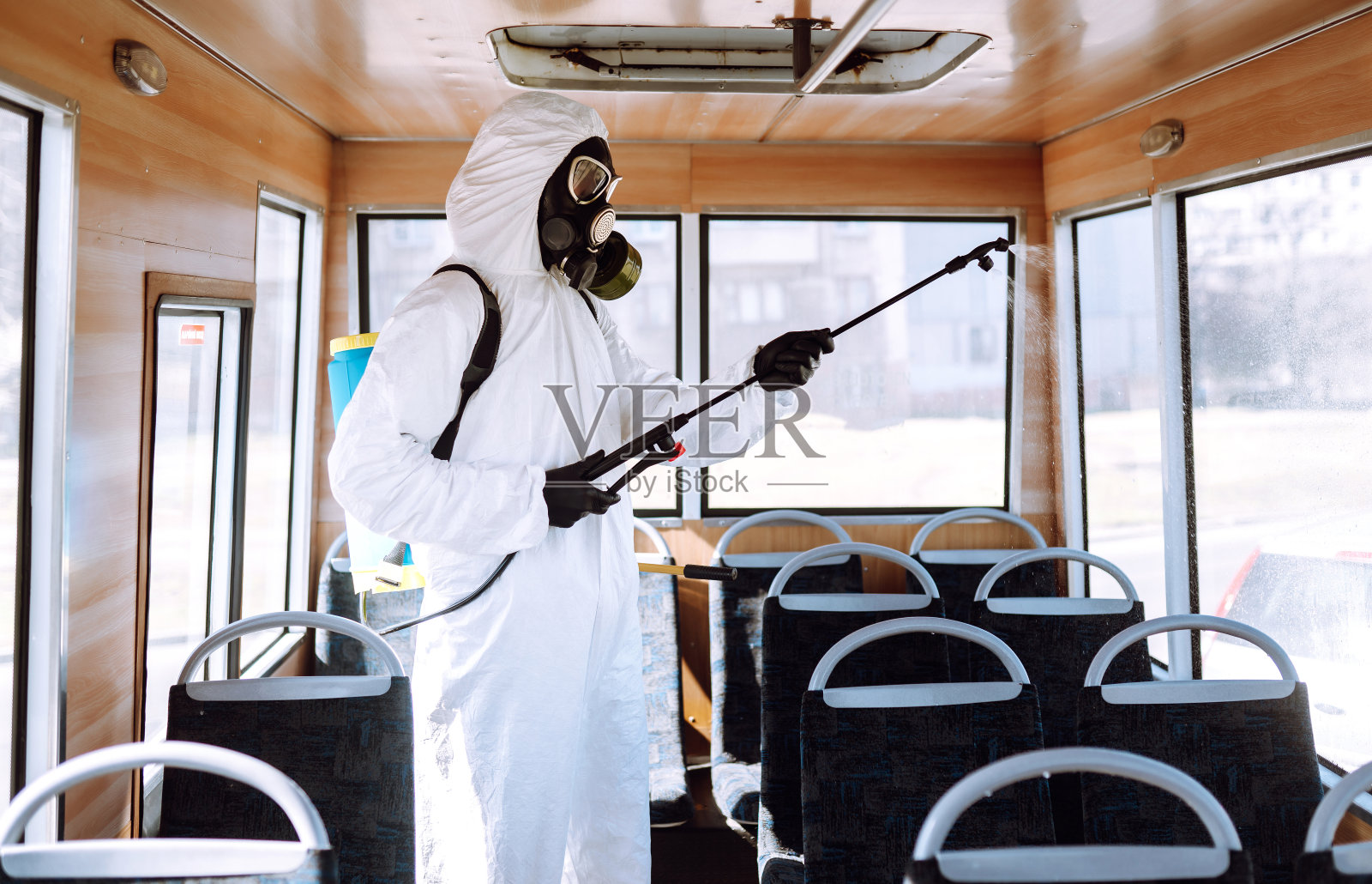 穿着防护服的人为公共交通消毒照片摄影图片