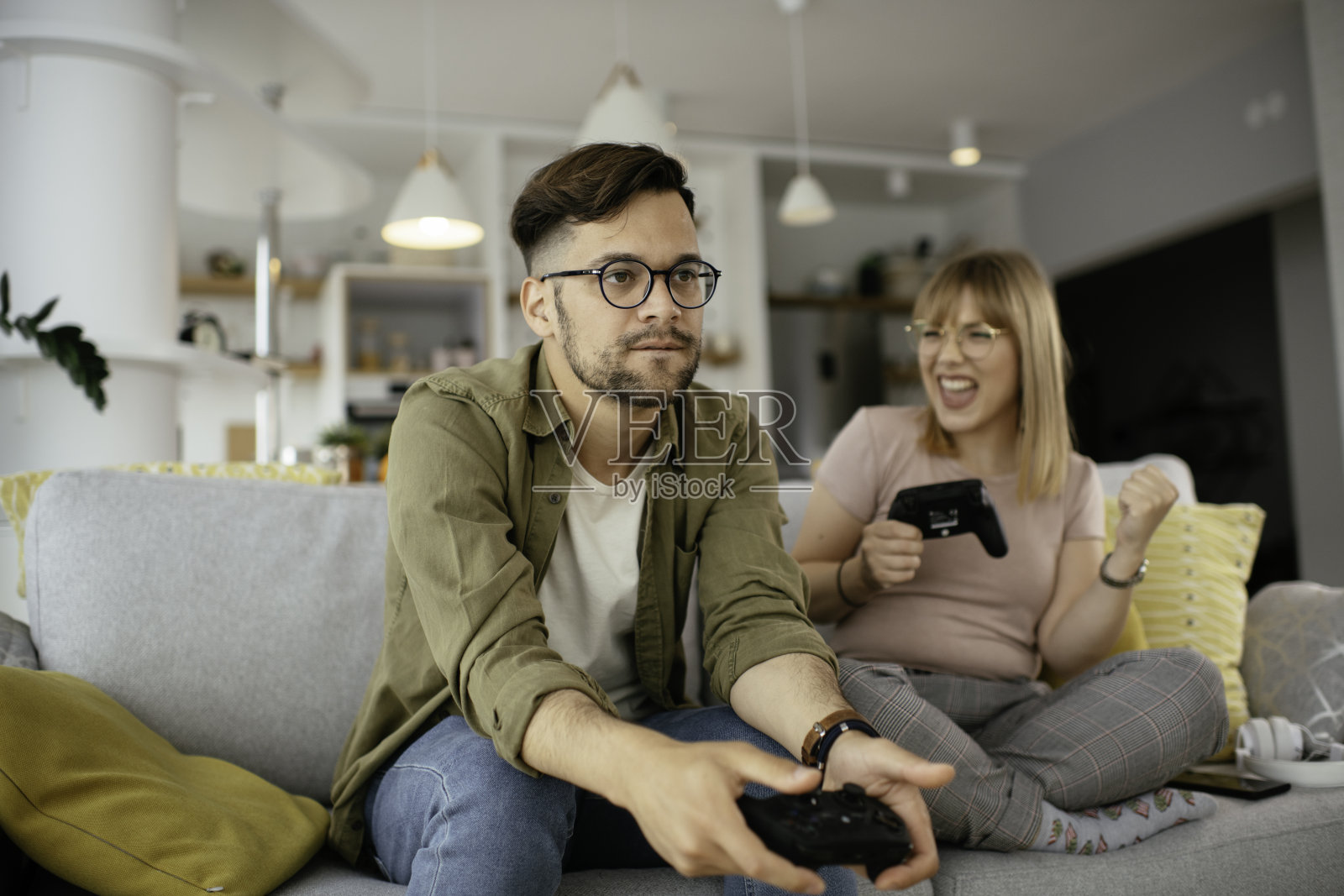 情侣在客厅用游戏手柄玩电子游戏照片摄影图片